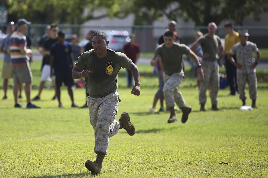 MARINE CORPS BASE HAWAII — Marines race while participating in an obstacle course during the 101 Days of Summer Field Meet Unit Challenge held at Riseley Field aboard Marine Corps Base Hawaii, Aug. 21, 2015. Hosted by Marine Corps Community Services Hawaii, the field meet was composed of a combat obstacle course, jousting, truck tire flip race, tug of war, 880-meter relay race and big trike relay. The field meet was held to promote health and wellness within the MCB Hawaii community, as well build camaraderie between various units around the base. Service members could earn points in the 101 Days of Summer Program by participating in this event. Events such as this help support the mission of MCCS Hawaii, which is to contribute to the readiness and retention of Marines, Sailors and families aboard MCB Hawaii by providing fitness and recreation programs, as well as business activities in garrison and deployed environments. (U.S. Marine Corps photo by Lance Cpl. Harley Thomas/Released)