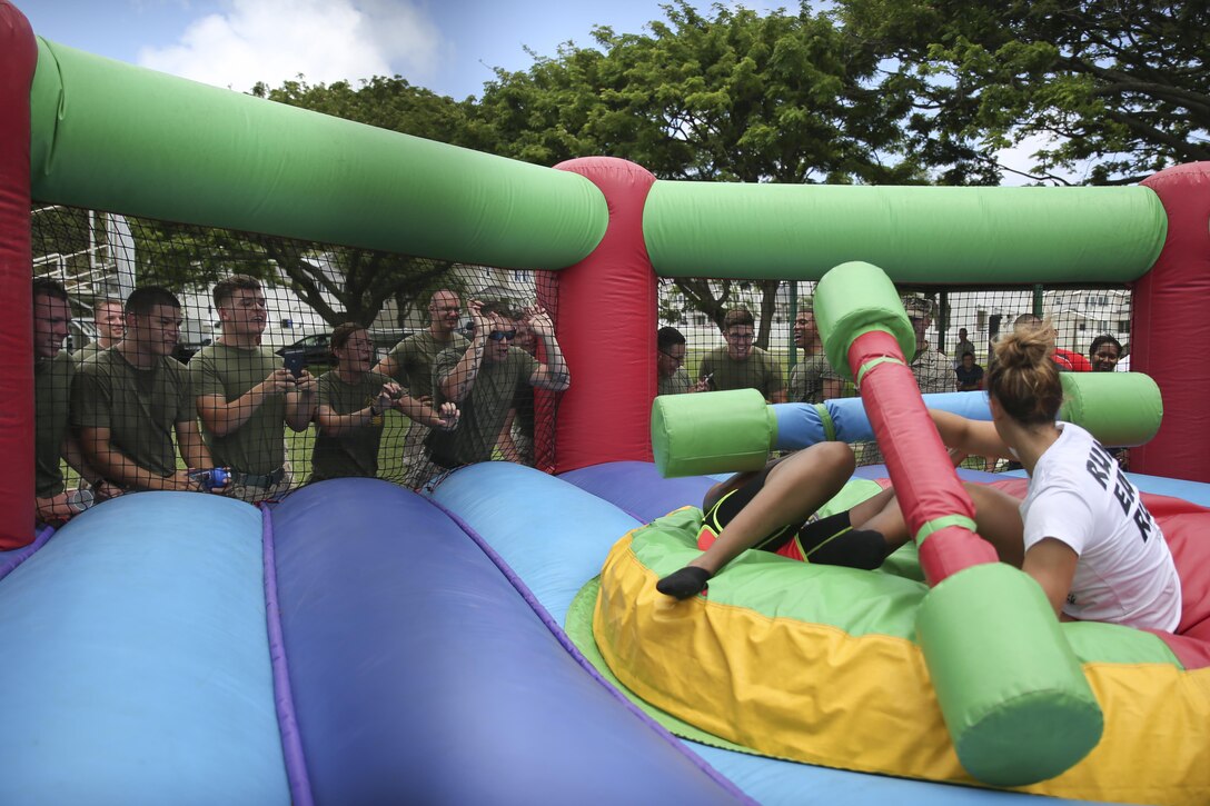 MARINE CORPS BASE HAWAII — Service members cheer on the jousting participants during the 101 Days of Summer Field Meet Unit Challenge held at Riseley Field aboard Marine Corps Base Hawaii, Aug. 21, 2015. Hosted by Marine Corps Community Services Hawaii, the field meet was composed of a combat obstacle course, jousting, truck tire flip race, tug of war, 880-meter relay race and big trike relay. The field meet was held to promote health and wellness within the MCB Hawaii community, as well build camaraderie between various units around the base. Service members could earn points in the 101 Days of Summer Program by participating in this event. Events such as this help support the mission of MCCS Hawaii, which is to contribute to the readiness and retention of Marines, Sailors and families aboard MCB Hawaii by providing fitness and recreation programs, as well as business activities in garrison and deployed environments. (U.S. Marine Corps photo by Lance Cpl. Harley Thomas/Released)