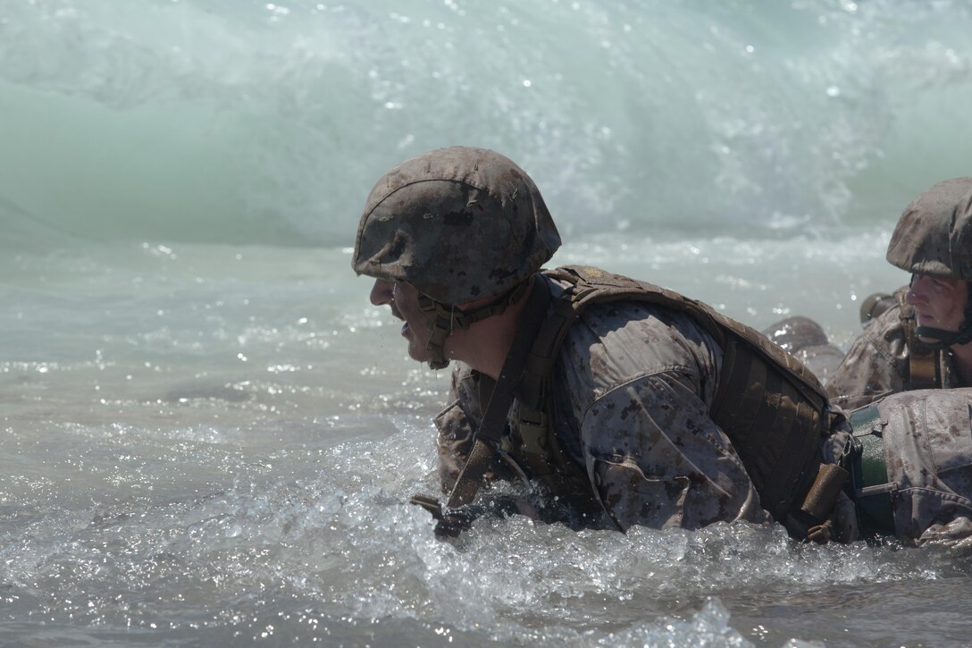 Sgt. Brett Oros, a food service specialist with Marine Wing Support Squadron 373 based out of Marine Corps Air Station Miramar and a Wallingford, Conn., native, braces himself as a wave builds itself to crash into him while he wades through the surf of Fort Hase beach aboard Marine Corps Base Hawaii during Sergeants Course Aug. 19, 2015. Oros, along with the other sergeants in the course, participated in a scenario where they were outnumbered 4 to 1, and needed to repair a broken down vehicle. Sergeants Course is a vital part of professional military education for any Marine and helps to maintain the standards amongst the NCOs of the Marine Corps. The course supports MCB Hawaii’s mission, which is to provide facilities, programs and services in direct support of units, individuals and families to enhance and sustain combat readiness for all operating forces and tenant organizations aboard the installation. 