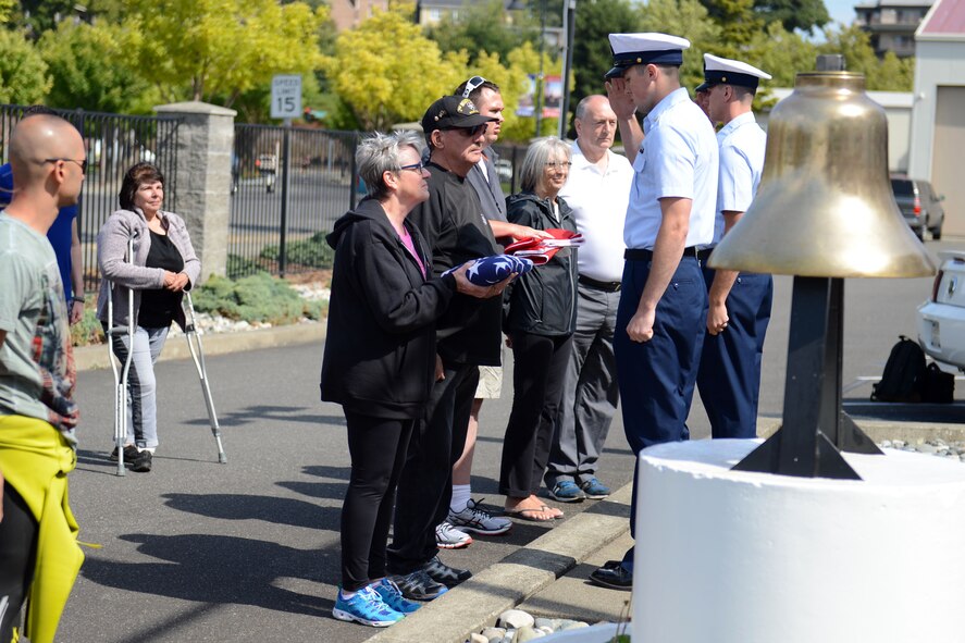 Petty Officer 2nd Class Patrick Joyce (foreground), U.S. Coast Guard boatswain’s mate, presents Romar and Pam Swarner the American flag and Seaman Brandon Saccoccio (background), U.S. Coast Guard seaman, presents Sheila and Shawn Fynes and Mike Langridge (center right) the Canadian flag in Bellingham, Wash., Aug. 24, 2015. Sheila and Shawn received the flag on behalf of their son Cpl. Stuart Langridge, Canadian Armed Forces, who lost his battle with Post-Traumatic Stress Disorder in March of 2008. (U.S. Air Force photo/Staff Sgt. Katie Jackson)