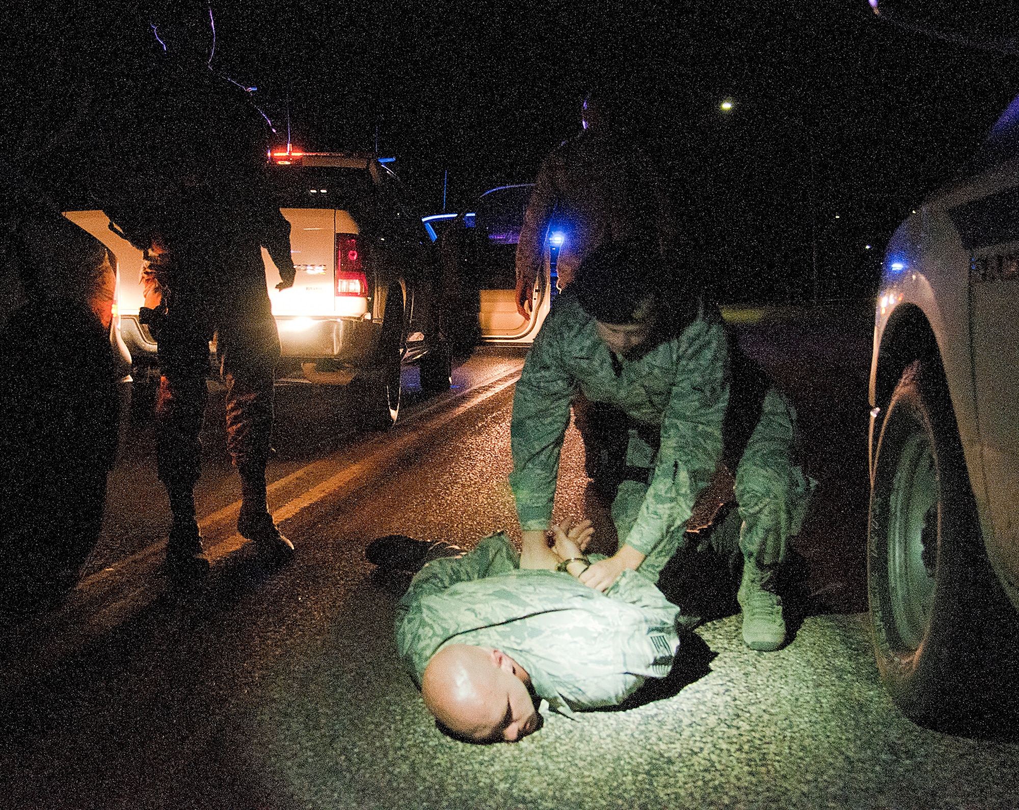 Senior Airman Zachary Downey, 90th Security Forces Squadron Delta Flight, pins down and handcuffs Technical Sgt. Andreas Niemetschek, 90th SFS Delta Flight chief, during a nighttime training exercise Aug. 6, 2015, on F.E. Warren Air Force Base, Wyo. Every shift, day and night, 90th SFS defenders undergo at least one training exercise to keep their law enforcement skills sharp. Niemetschek simulated a gate runner and led Delta Flight on a car chase through the base before being surrounded and subdued. Niemetschek was not apprehended except for exercise purposes only. (U.S. Air Force photo by Senior Airman Jason Wiese/Released)