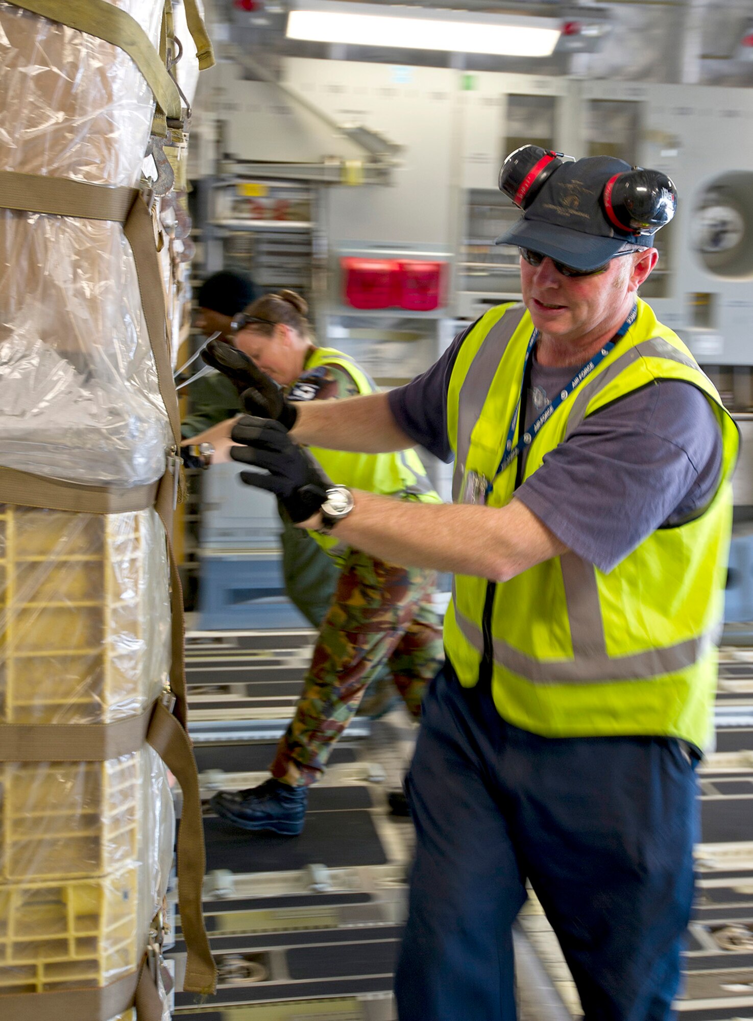 Members of the Royal New Zealand Air Force and U.S. Air Force Master Sgt. Tim Reed, 304th Expeditionary Airlift Squadron loadmaster, work together to push a cargo pallet onto a U.S. Air Force C-17 Globemaster III at Christchurch International Airport, New Zealand, Aug. 23, 2015 before the first mission of WINFLY 2015-2016 season. WINFLY missions set the stage for the U.S. Antarctic Program (USAP) research season, which begins in October. The National Science Foundation manages the USAP. Along with working with the RNZAF, Operation Deep Freeze provides military logistical support to the USAP. (U.S. Air Force photo by Senior Airman Madelyn McCullough)