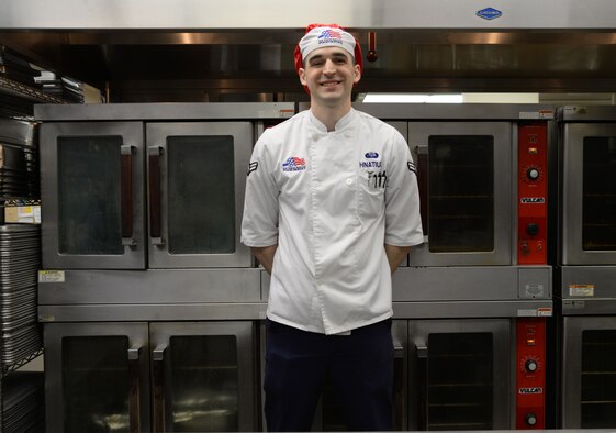 U.S. Air Force Airman 1st Class Jeremy P. Hnatiuk, a 354th Force Support Squadron shift leader, takes a break to smile in front of the ovens in the Two Seasons Dining Facility, Aug. 27, 2015, at Eielson Air Force Base, Alaska. Hnatiuk said his favorite part of the job is cooking, which is something he has always loved to do. (U.S. Air Force photo by Airman 1st Class Cassandra Whitman/Released)