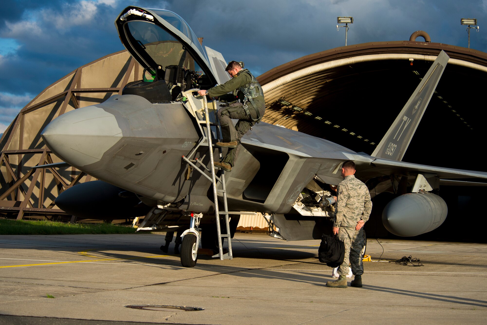 An F-22 Raptor fighter aircraft pilot assigned to the 95th Fighter Squadron at Tyndall Air Force Base, Fla., exits an F-22 at Spangdahlem Air Base, Germany, Aug. 28, 2015. The U.S. Air Force deployed four F-22 Raptors, one C-17 Globemaster III and more than 50 Airmen to Spangdahlem in support of the first F-22 European training deployment. The inaugural F-22 training deployment to Europe is funded by the European Reassurance Initiative, a $1 billion pledge announced by President Obama in March 2014.(U.S. Air Force photo by Airman 1st Class Luke Kitterman/Released)
