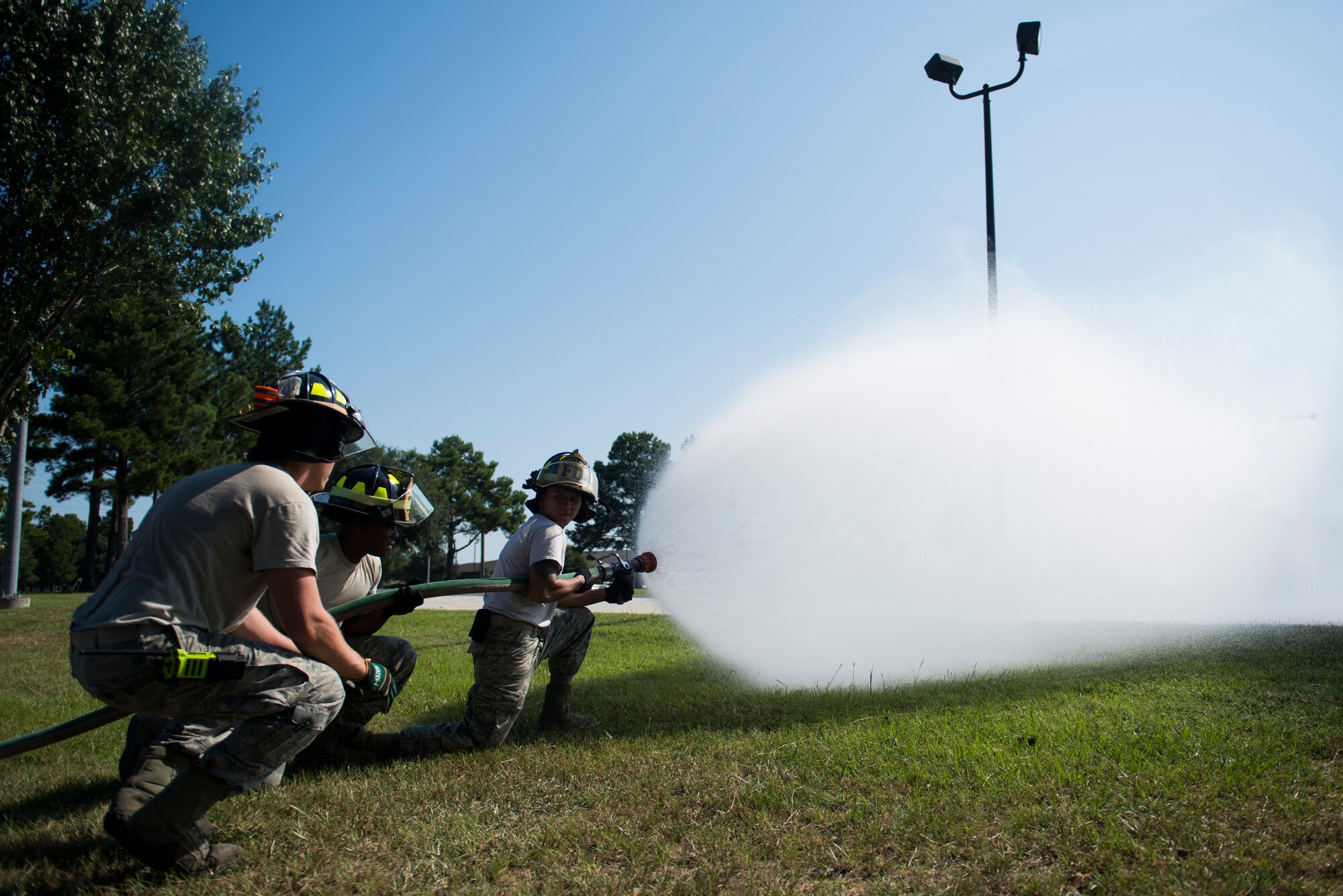 Fire protection journeymen from the 23d Civil Engineer Squadron, stabilize an attack pump during pump operations training Aug. 27, 2015, at Moody Air Force Base, Ga. Moody firefighters utilize the attack pump as their main source of fire protection due to high mobility and water pressure. (U.S. Air Force Airman 1st Class Dillian Bamman/Released)