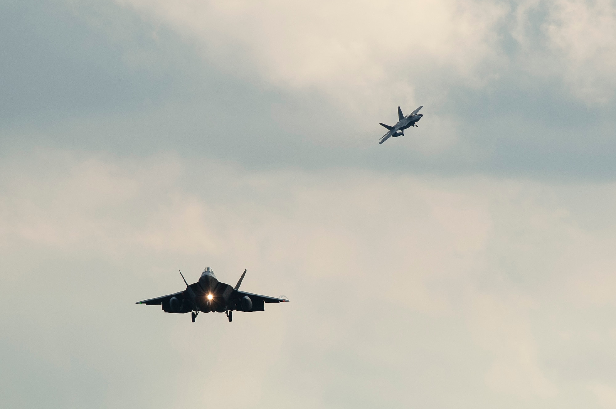 Two F-22 Raptor fighter aircraft prepare to land at Spangdahlem Air Base, Germany, Aug. 28, 2015 as part of the inaugural F-22 training deployment to Europe. Four F-22s from the 95th Fighter Squadron at Tyndall Air Force Base, Fla., along with a C-17 Globemaster III cargo aircraft and more than 50 support Airmen were part of the deployment. This effort is part of the European Reassurance Initiative and will serve to assure allies of the Air Force’s commitment to European security and stability. (U.S. Air Force photo by Staff Sgt. Chad Warren/Released)