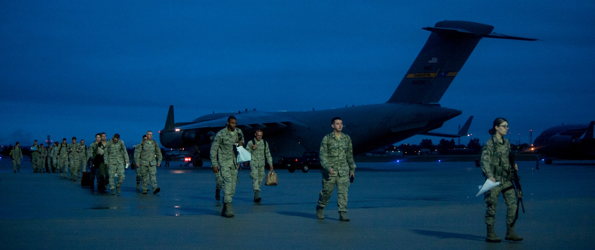 Airmen from the 95th Fighter Squadron depart from a U.S. Air Force C-17 Globemaster III on the flightline at Spangdahlem Air Base, Germany, Aug. 28, 2015. The Airmen are here to support the first ever F-22 Raptor European training deployment. This deployment is part of the European Reassurance Initiative, which is intended to increase the capability, readiness and responsiveness of NATO forces in part by funding rotational force presence in Eastern Europe. (U.S. Air Force photo by Senior Airman Rusty Frank/Released)