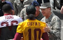 Air Force District of Washington Commander Maj. Gen. Darryl Burke greets Washington Redskins quarterback Robert Griffin III just before the Washington Redskins conduct a walkthrough practice at the fitness center's field, Joint Base Andrews, Md. on Aug. 28, 2015. The Redskins spent time meeting with Airmen, Sailors and Marines, family members and local school children and their chaperones to show their appreciation to the military community. The Redskins conducted the practice and signed autographs as part of their Redskins Salute effort. (U.S. Air Force photo/James E. Lotz) 