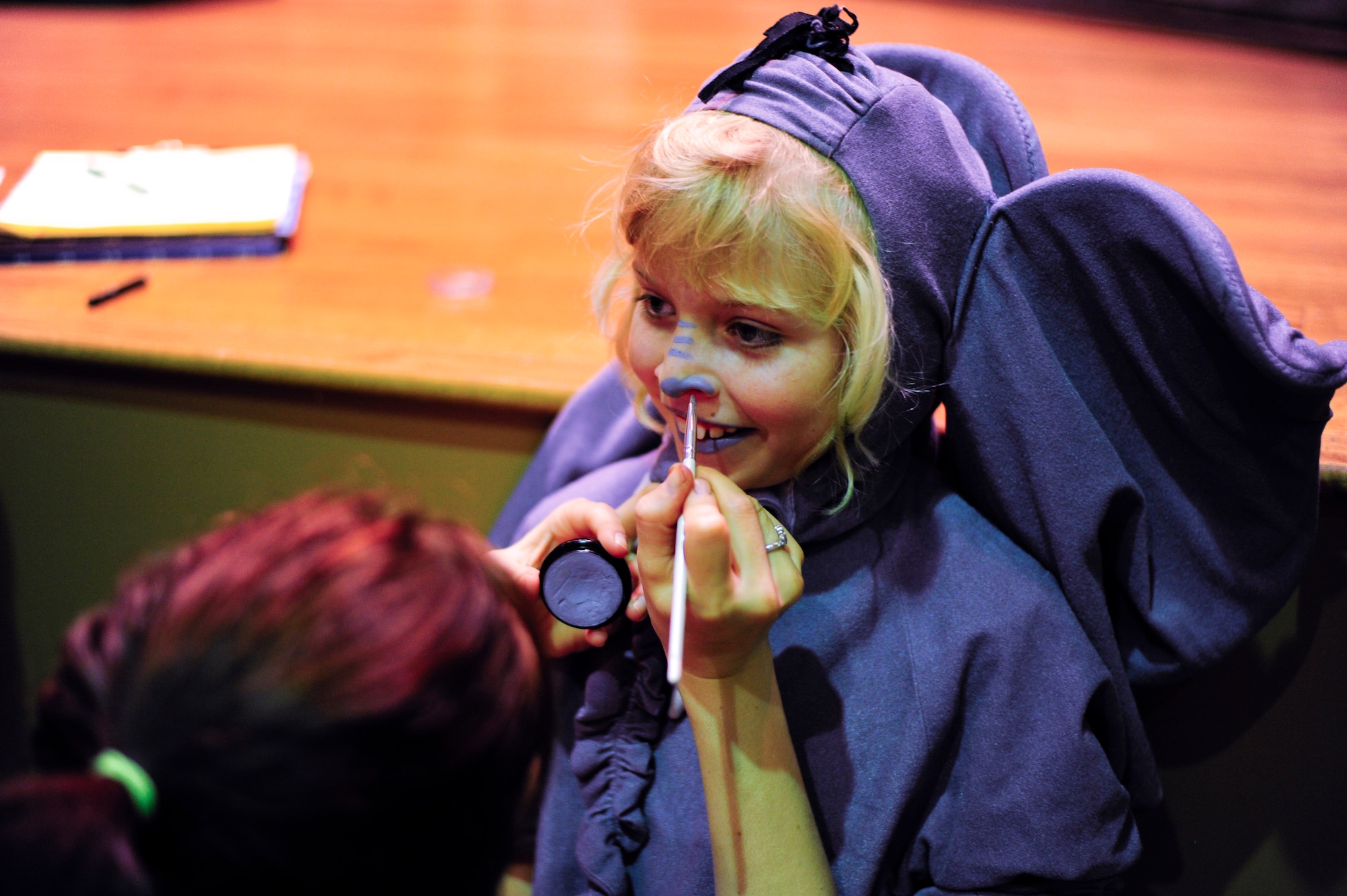 A child stands still as she receives the final touch on her costume, minutes before her performance in "Jungle Book" at MacDill Air Force Base, Fla., Aug. 21, 2015. Children participants can range in age from ages five to 18. (U.S. Air Force photo by Airman 1st Class Mariette M. Adams/Released)