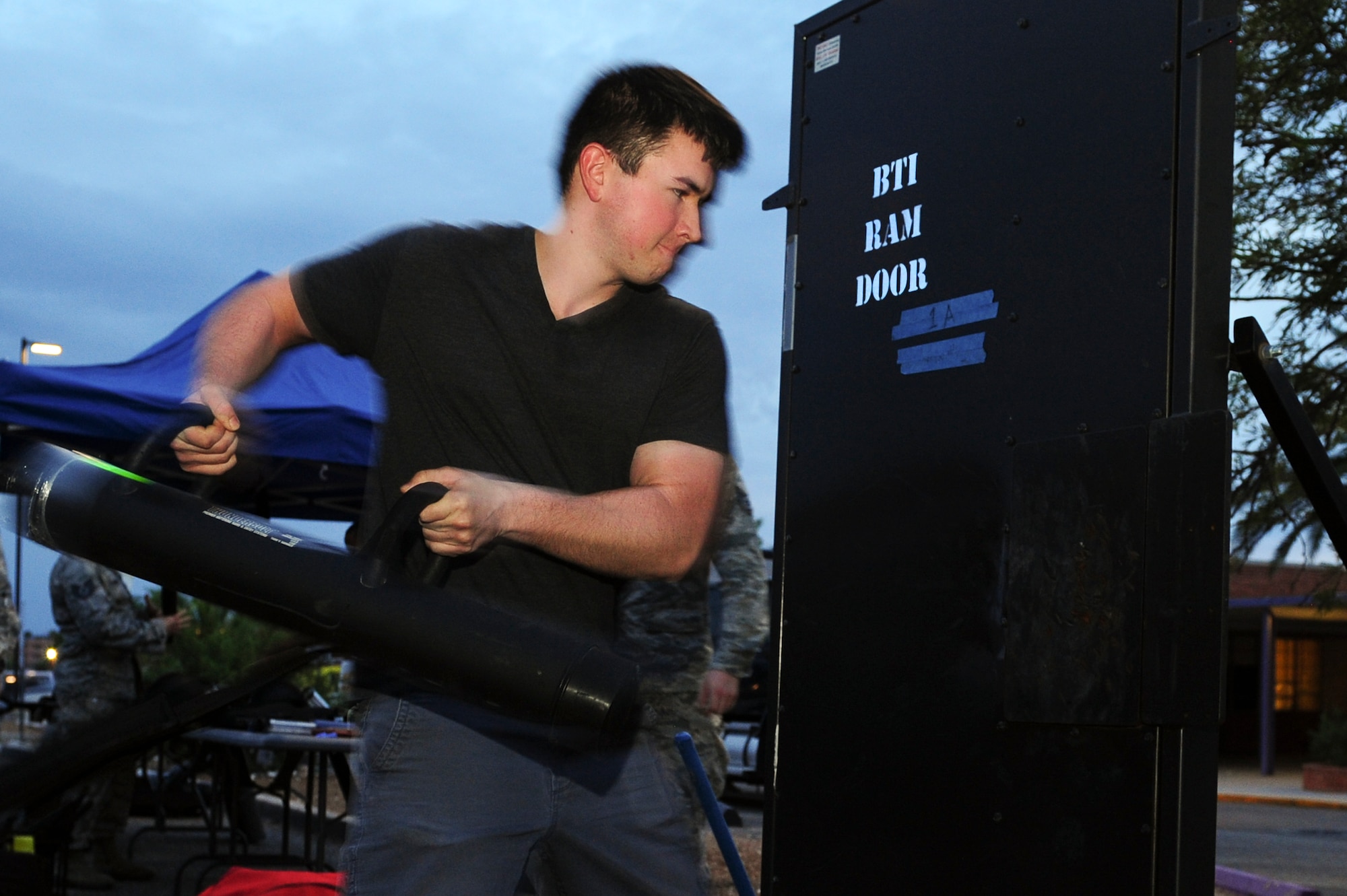 Mike Mann, Tucson resident, swings a battering ram at a steel door provided by the 355th Security Forces Squadron during a Meet and Greet event at Rincon High School, Tucson, Ariz., Aug 26, 2015. The Tucson community was invited to the event and encouraged to interact with its neighboring Airmen and learn more about the mission of Davis-Monthan Air Force Base. (U.S. Air Force photo by Airman 1st Class Chris Drzazgowski/Released)