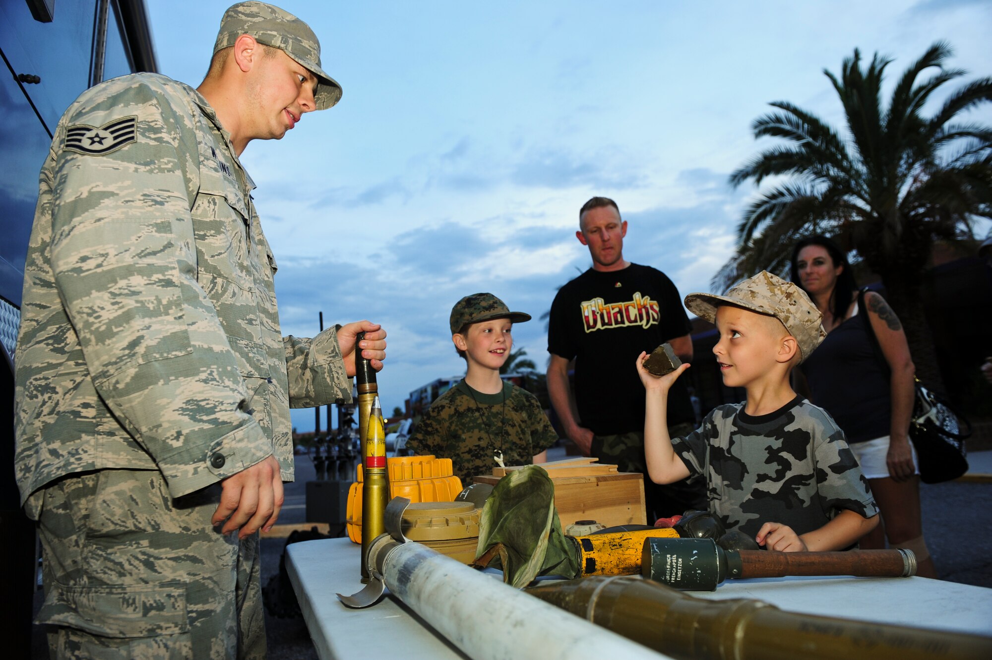 Jack Scholer, age 5, asks Staff Sgt. Kevin Wilkinson, 355th Civil Engineering Squadron explosive ordnance disposal technician, questions about training ordnance during a Meet and Greet event at Rincon High School, Tucson, Ariz., Aug. 26, 2015. U.S. Air Force Airmen from more than 10 organizations at Davis-Monthan Air Force Base were available to share their stories and provide a glimpse into their daily duties. (U.S. Air Force photo by Airman 1st Class Chris Drzazgowski/Released)