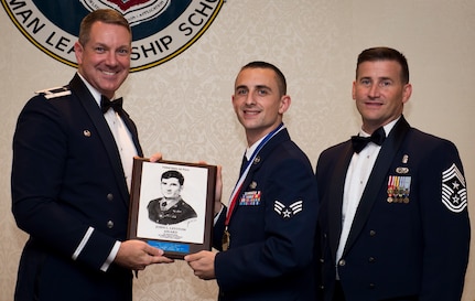 Col. Robert Lyman, Joint Base Charleston commander and Chief Master Sgt. Mark Bronson, 628th Air Base Wing command chief present the John L. Levitow Award to Senior Airman Patrick Esmerado, 628th Logistics Readiness Squadron supply technician Aug. 27, 2015, at the Charleston Club on JB Charleston, S.C. The John L. Levitow award is given for a student’s exemplary demonstration of excellence, both as a leader and a scholar. (U.S. Air Force photo/Airman 1st Class Clayton Cupit)