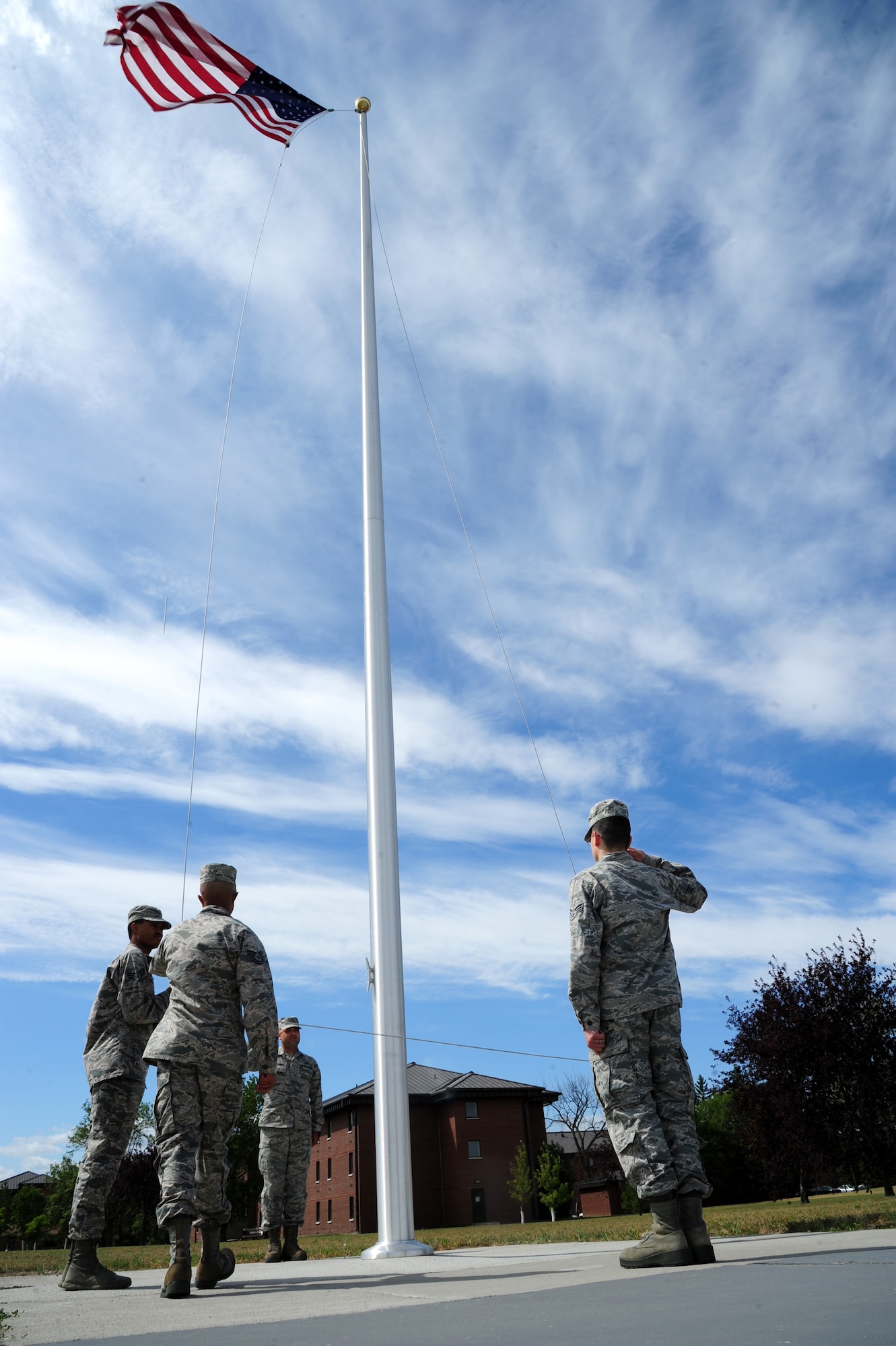 Airmen from the 319th Air base Wing practice lowering the flag before a formal retreat ceremony August 19, 2015, on Grand Forks Air Force Base, North Dakota. A different squadron is responsible for supplying a flag detail and a flight to perform a formal retreat ceremony each week during spring and summer. (U.S. Air Force photo by Airman 1st Class Ryan Sparks/Released)