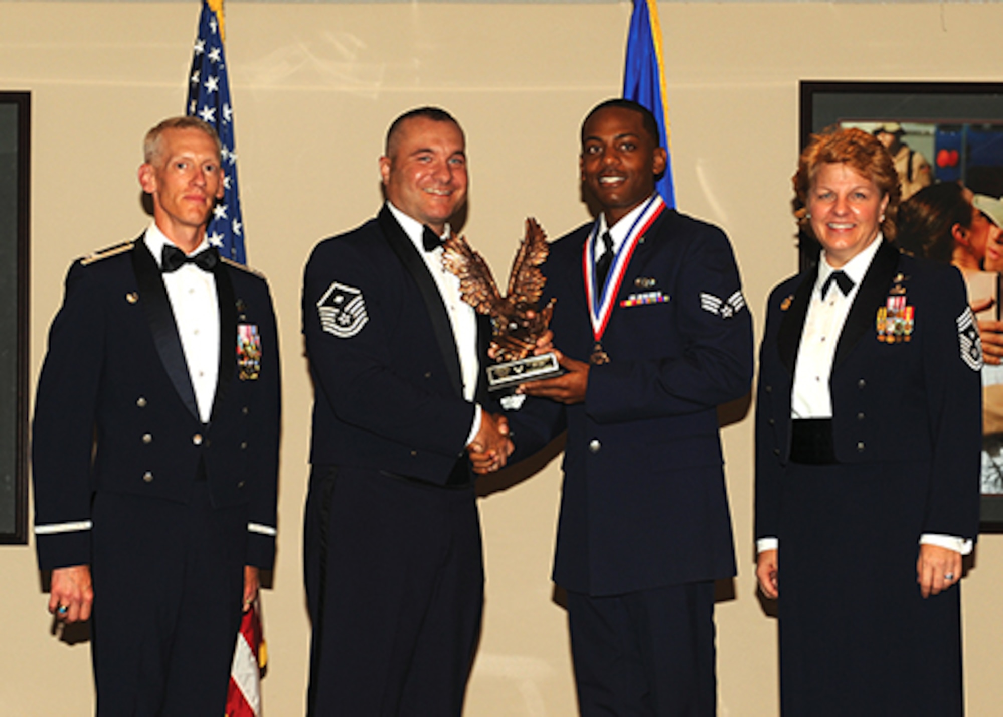 Col. Christopher Bennett (far left), 19th Airlift Wing Vice Commander, along with Chief Master Sgt. Rhonda Buening (far right), 19th AW Command Chief and Master Sgt. Jason Crouse, 19th Security Forces Squadron First Sergeant. (left), congratulate Senior Airman Jamaar Jackson during the graduation ceremony. (Air Force Photo/Senior Airman Scott Poe)