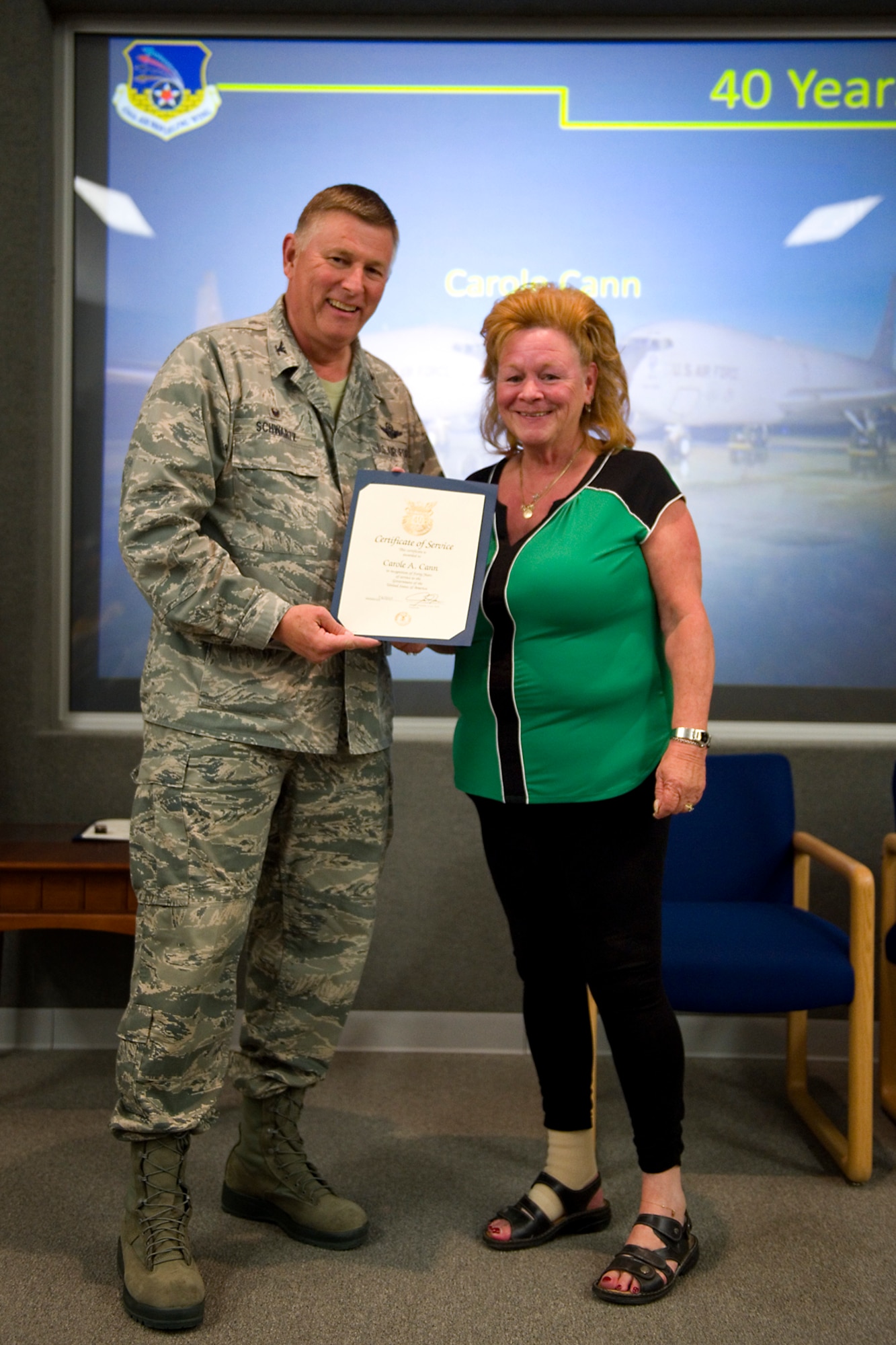 Col. Doug Schwartz, 434th Air Refueling Wing commander, presents Carole Cann, 434th Logistics Readiness Squadron, with a certificate of service for completing 40 years as a federal employee during a civilian commander's call at Grissom Air Reserve Base, Ind., Aug. 25, 2015. Civil service employees are an essential part Grissom and serve critical roles in maintaining unit readiness and daily operations. (U.S. Air Force photo/Tech. Sgt. Benjamin Mota)