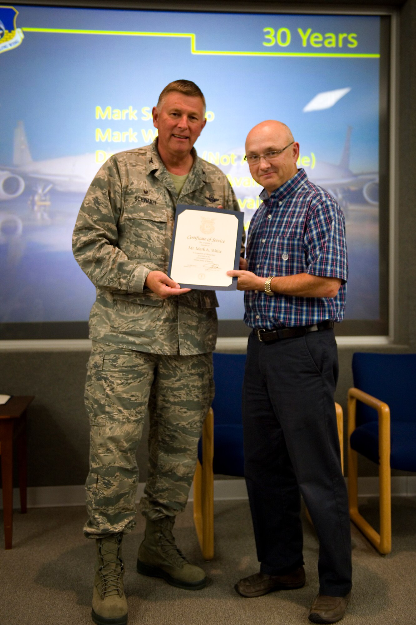 Col. Doug Schwartz, 434th Air Refueling Wing commander, presents Mark Waite, 434th Civil Engineer Squadron, with a certificate of service for completing 30 years as a federal employee during a civilian commander's call at Grissom Air Reserve Base, Ind., Aug. 25, 2015. Civil service employees are an essential part Grissom and serve critical roles in maintaining unit readiness and daily operations. (U.S. Air Force photo/Tech. Sgt. Benjamin Mota)