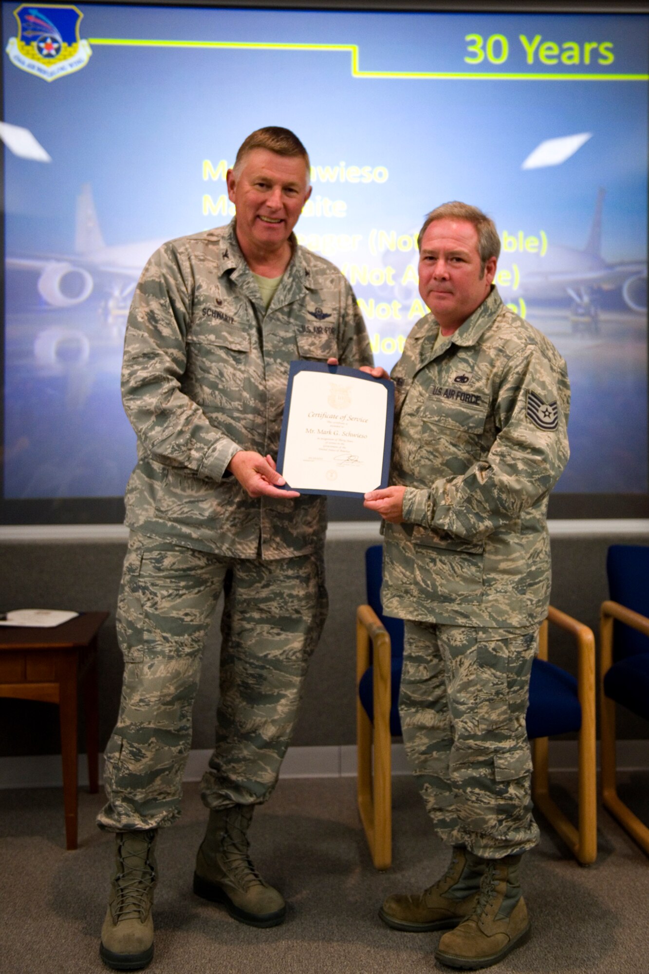 Col. Doug Schwartz, 434th Air Refueling Wing commander, presents Mark Schwieso, 434th Aircraft Maintenance Squadron, with a certificate of service for completing 30 years as a federal employee during a civilian commander's call at Grissom Air Reserve Base, Ind., Aug. 25, 2015. Civil service employees are an essential part Grissom and serve critical roles in maintaining unit readiness and daily operations. (U.S. Air Force photo/Tech. Sgt. Benjamin Mota)