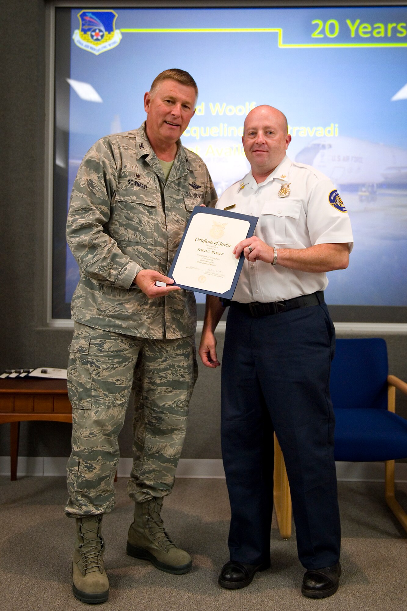 Col. Doug Schwartz, 434th Air Refueling Wing commander, presents Todd Woolf, 434th Civil Engineer Squadron, with a certificate of service for completing 20 years as a federal employee during a civilian commander's call at Grissom Air Reserve Base, Ind., Aug. 25, 2015. Civil service employees are an essential part Grissom and serve critical roles in maintaining unit readiness and daily operations. (U.S. Air Force photo/Tech. Sgt. Benjamin Mota)