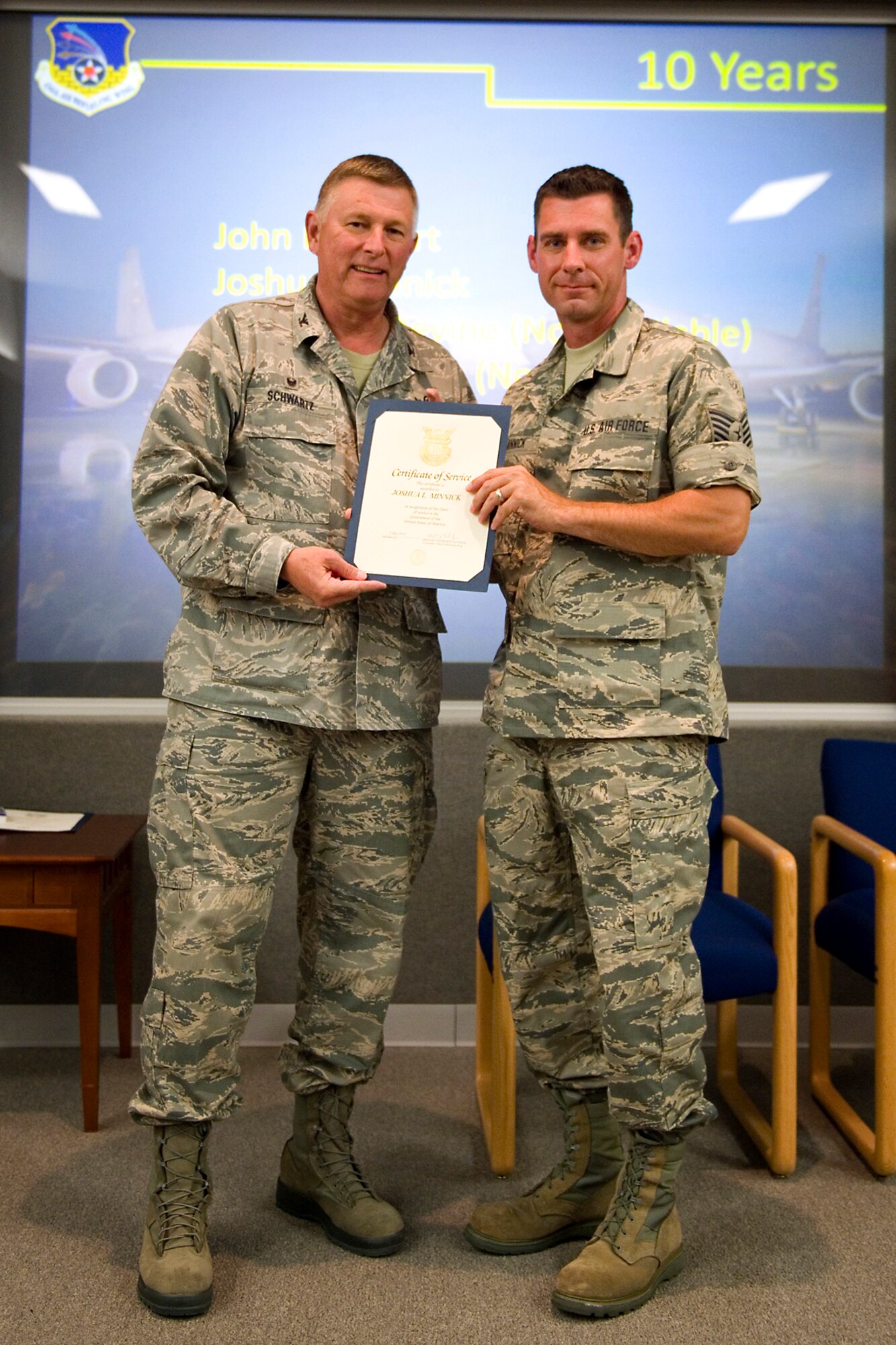 Col. Doug Schwartz, 434th Air Refueling Wing commander, presents Joshua Minnick, 434th Operations Support Squadron, with a certificate of service for completing 10 years as a federal employee during a civilian commander's call at Grissom Air Reserve Base, Ind., Aug. 25, 2015. Civil service employees are an essential part Grissom and serve critical roles in maintaining unit readiness and daily operations. (U.S. Air Force photo/Tech. Sgt. Benjamin Mota)
