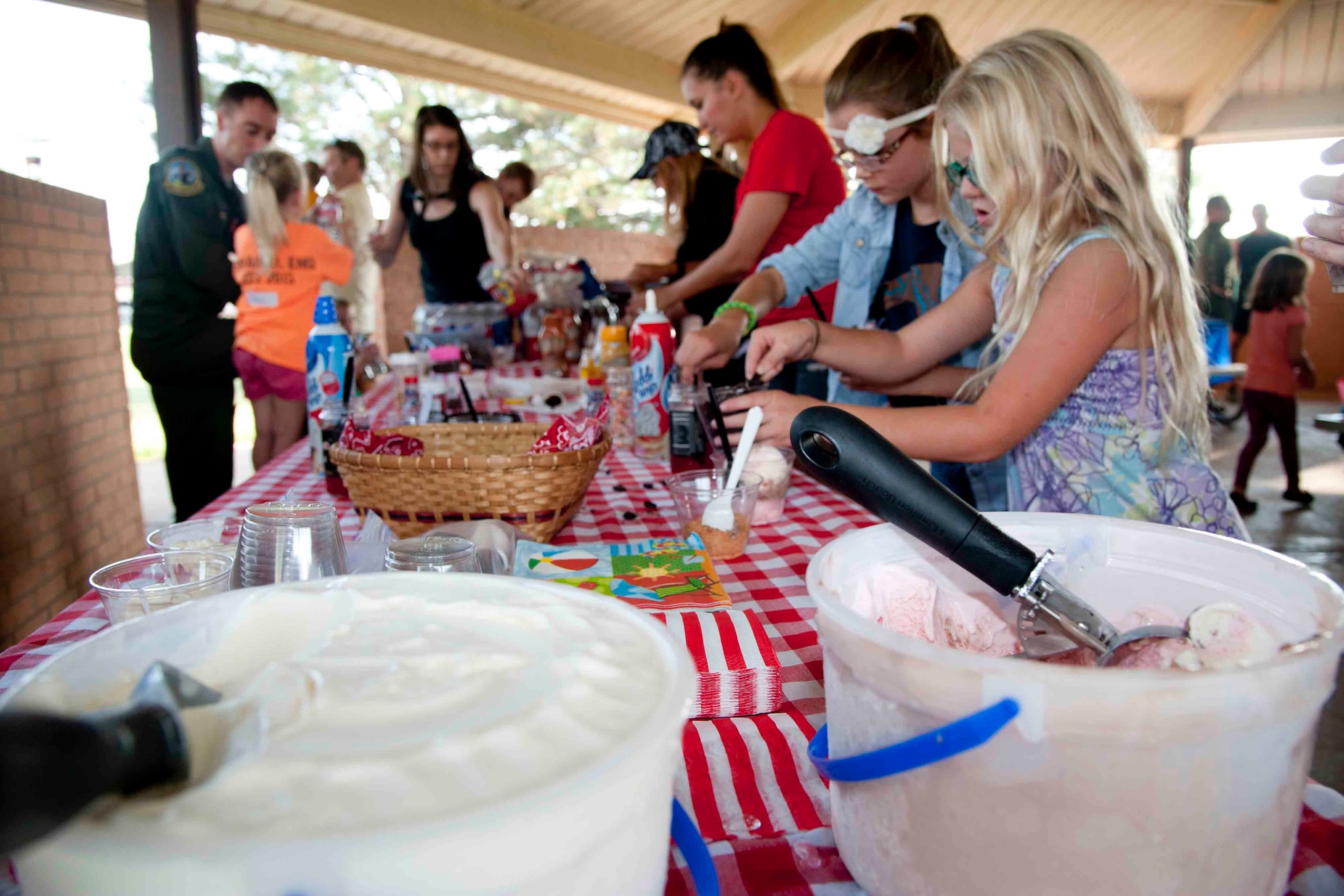 Families line up for a treat during a spouses group ice cream social and membership drive Aug. 25 at the Base Park. The Officers’ Spouses’ Club and the Enlisted Spouses’ Group will merge into one group in September and become the Vance Spouses’ Club. (U.S. Air Force photo / Staff Sgt. Nancy Falcon)