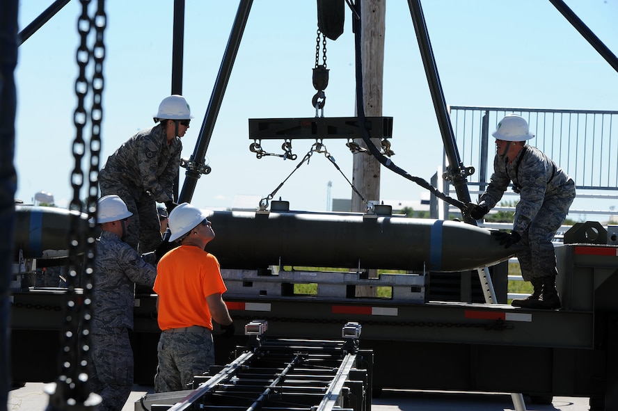 Airmen from the 5th Munitions Squadron Global Strike Challenge team load a 2000 pound BLU-109 bomb body onto the MAC II assembly conveyor for assembly at Minot Air Force Base, N.D., Aug. 24, 2015. The team practiced for their upcoming competition at Barksdale Air Force Base, LA. (U.S. Air Force photo / Senior Airman Kristoffer Kaubisch)