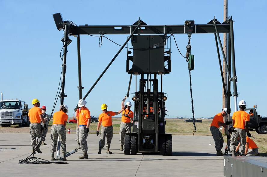 The 5th Munitions Squadron Global Strike Challenge team raises a munitions assembly conveyor at Minot Air Force Base, N.D., Aug. 24, 2015. The assembly conveyor allows for rapid assembly of multiple weapon systems. (U.S. Air Force photo / Senior Airman Kristoffer Kaubisch)