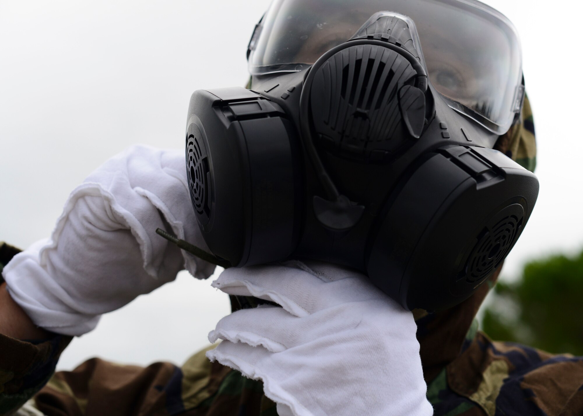 U.S. Air Force Senior Airman Justin Trivett, 31st Civil Engineer Squadron electrical systems journeyman, dawns protective gear during a monthly prime base engineer emergency force, or Prime BEEF, training exercise, Aug. 25, 2015, at Aviano Air Base, Italy. Training participants had to complete a vehicle familiarization course in Mission Oriented Protective Posture level four (MOPP 4) as part of the exercise. (U.S. Air Force photo by Senior Airman Austin Harvill/Released)