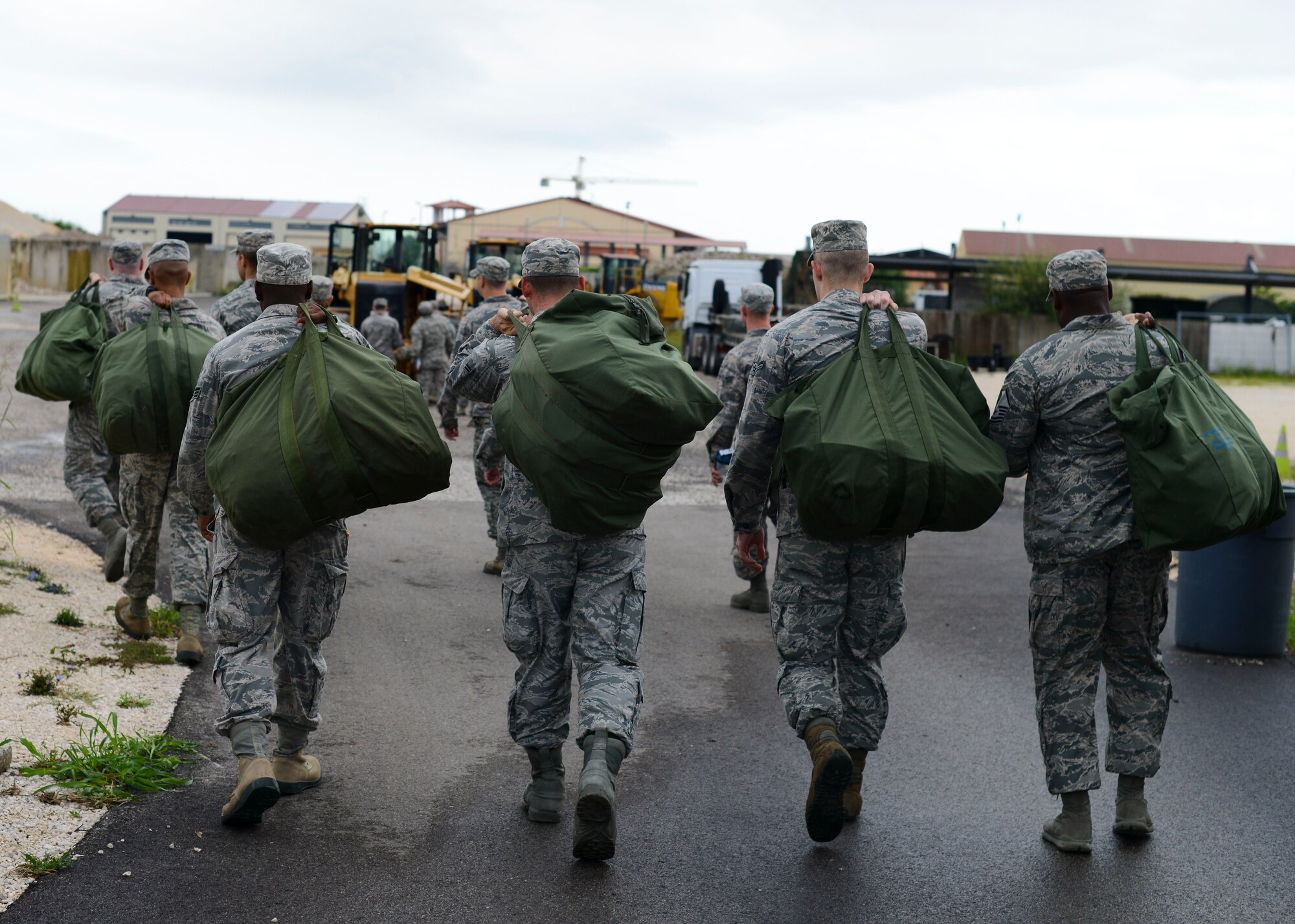 Airmen from the 31st Civil Engineer Squadron walk toward a monthly prime base engineer emergency force, or Prime BEEF, training exercise, Aug. 25, 2015, at Aviano Air Base, Italy. The training involved operating a 10k all-terrain forklift and driving standard vehicles while in Mission Oriented Protective Posture level four (MOPP 4). (U.S. Air Force photo by Senior Airman Austin Harvill/Released)