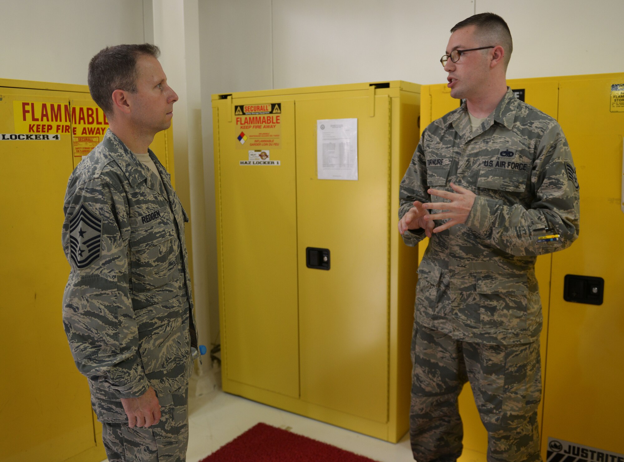 Chief Master Sgt. Mark Redden, 521st Air Mobility Operations Wing command chief, speaks with Staff Sgt. Thomas Turnure, 728th Air Mobility Squadron program manager Aug. 24, 2015, at Incirlik Air Base, Turkey. Turnure spoke with Redden about improvements the 728th AMS has instated regarding the storage of hazardous materials. (U.S. Air Force photo by Senior Airman Krystal Ardrey/Released)