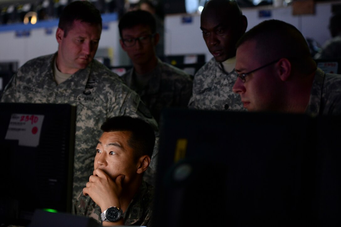 U.S. Army members from the 3rd Battlefield Coordination Detachment - Korea observe Republic of Korea Air Force Maj. Son, Sanghyun, the unit’s air and ground operations officer-in-charge, while he relays information to the Air Control Center during exercise Ulchi Freedom Guardian Aug. 21, 2015, at the Hardened Theater Air Control Center, Osan Air Base, Republic of Korea. The detachment is the Army’s only combined forces BCD comprised of combined forces. (U.S. Air Force photo/Airman 1st Class John Linzmeier)