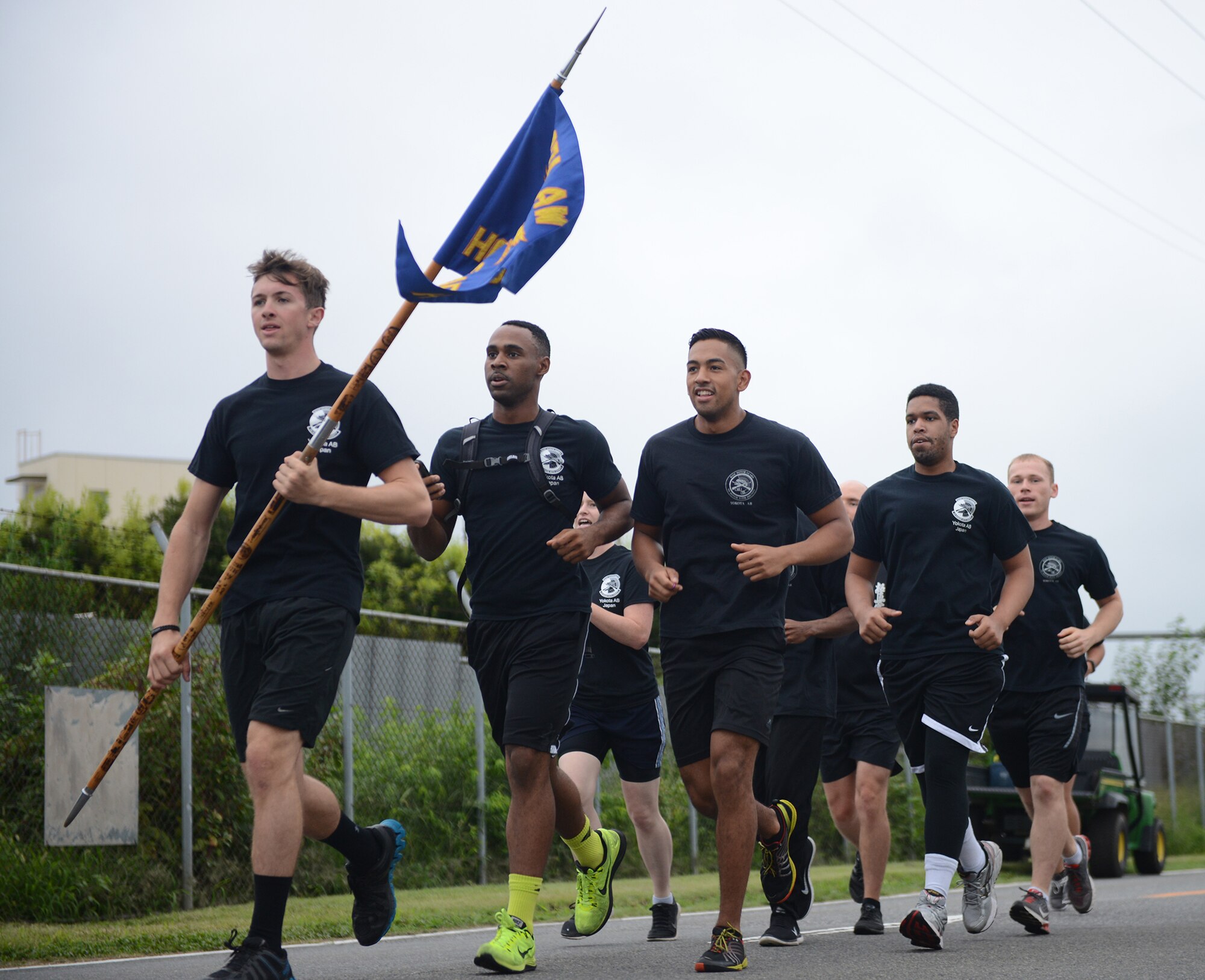 Yokota honor guardsmen run in formation during the 'Football Frenzy 5K' at Yokota Air Base, Japan, Aug. 28, 2015. More than 200 people from around base participated in the event that promoted healthy lifestyles. (U.S. Air Force photo by Senior Airman David C. Danford/Released)