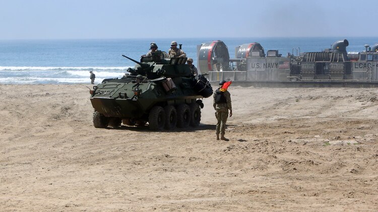 Marines with 3rd Light Armored Reconnaissance Battalion, 1st Marine Division, maneuver their light armored vehicles off Landing Craft Air Cushions (LCACs) from the Navy’s Assault Craft Unit 5, during an amphibious raid demonstration in conjunction with a visit from the secretary of defense, aboard Marine Corps Base Camp Pendleton, Calif., Aug. 27, 2015. The LCACs transported the LAVs and Marines from the USS New Orleans (LDP 18) while Marines from Company A, 1st Battalion, 1st Marine Regiment, 1st Mar. Div. used amphibious assault vehicles with 3rd Assault Amphibian Battalion, 1st Mar. Div. to assault their objective. 