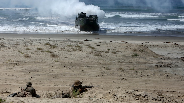 Marines with 1st Reconnaissance Battalion, 1st Marine Division, reconnoiter the beach as Company A, 3rd Assault Amphibian Battalion, 1st Mar. Div., maneuvers ashore during an amphibious raid demonstration in conjunction with a visit from the secretary of defense, aboard Marine Corps Base Camp Pendleton, Calif., Aug. 27, 2015.   The amphibious assault vehicles transported infantrymen with Company A, 1st Battalion, 1st Marine Regiment, 1st Mar. Div. to shore after disembarking the amphibious transport dock ship USS New Orleans (LPD 18) while 3rd Light Armored Reconnaissance Battalion, 1st Mar. Div., provided additional security.