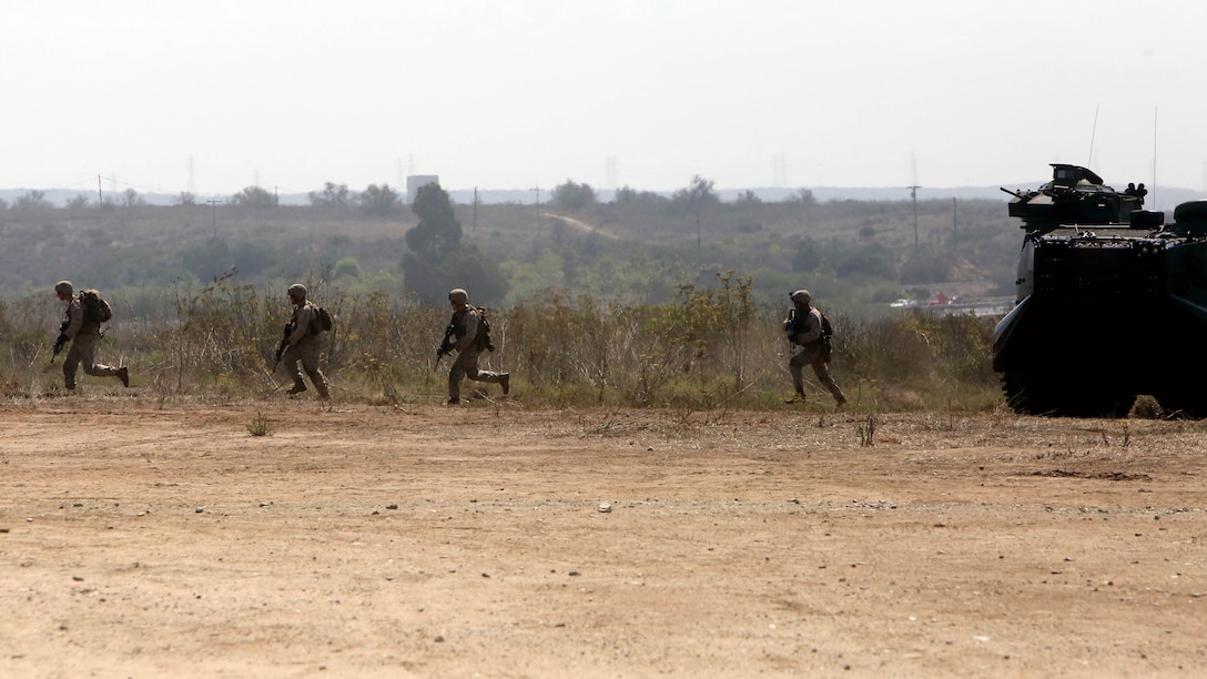 Marines with Company A, 1st Battalion, 1st Marine Regiment, 1st Marine Division, run to assault a “combat town” after exiting an amphibious assault vehicle with 3rd Assault Amphibian Battalion, 1st Mar. Div., during an amphibious raid demonstration in conjunction with a visit from the secretary of defense, aboard Marine Corps Base Camp Pendleton, Calif., Aug. 27, 2015.   The AAVs transported infantrymen with Company A, 1st Battalion, 1st Marine Regiment, to shore after exiting the amphibious transport dock ship USS New Orleans (LDP 18) while 3rd Light Armored Reconnaissance Battalion provided additional security. 