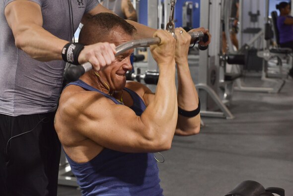 Maj. Keith Vanderhoeven, Air Force Central Command Combined Air Operations Center director of lessons learned, completes a reverse close-grip lat pull down during a workout session August 23, 2015 Al Udeid Air Base, Qatar. (U.S. Air Force photo/Staff Sgt. Alexandre Montes) 