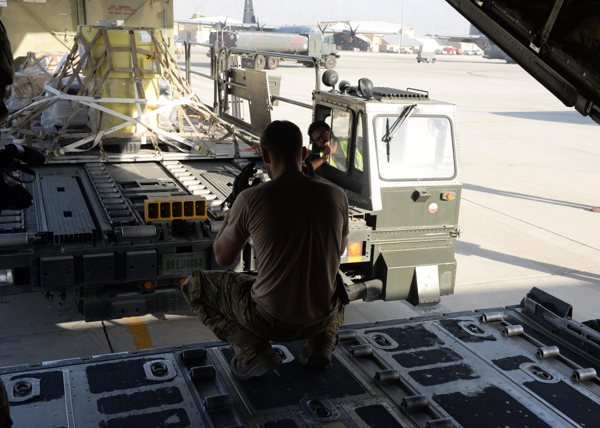 U.S. Air Force Staff Sgt. Casey Strauss, 774th Expeditionary Airlift Squadron C-130J Super Hercules loadmaster, directs a truck as its moves cargo onto the aircraft Aug. 28, 2015, at Bagram Airfield, Afghanistan. Strauss and his fellow loadmasters are responsible for loading and unloading cargo, passenger safety in flight, and ensuring the aircraft stays within the proper weight and balance limitations. (U.S. Air Force photo by Senior Airman Cierra Presentado/Released)