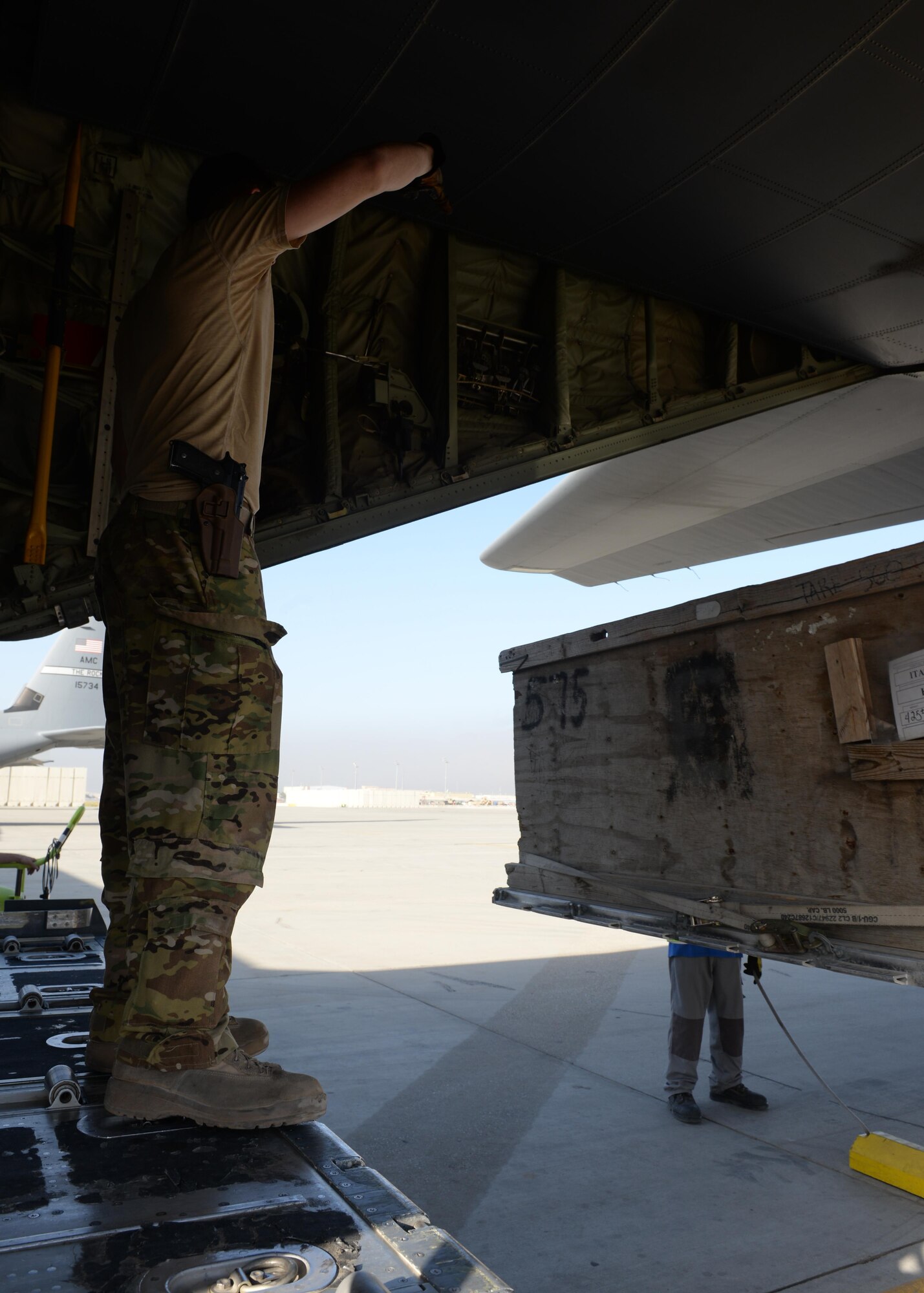 U.S. Air Force Staff Sgt. Casey Strauss, 774th Expeditionary Airlift Squadron C-130J Super Hercules loadmaster, directs a cargo truck as it moves cargo onto an aircraft Aug. 28, 2015, at Bagram Airfield, Afghanistan. Strauss and his fellow loadmasters are responsible for loading and unloading cargo, passenger safety in flight, and ensuring the aircraft stays within the proper weight and balance limitations. (U.S. Air Force photo by Senior Airman Cierra Presentado/Released)