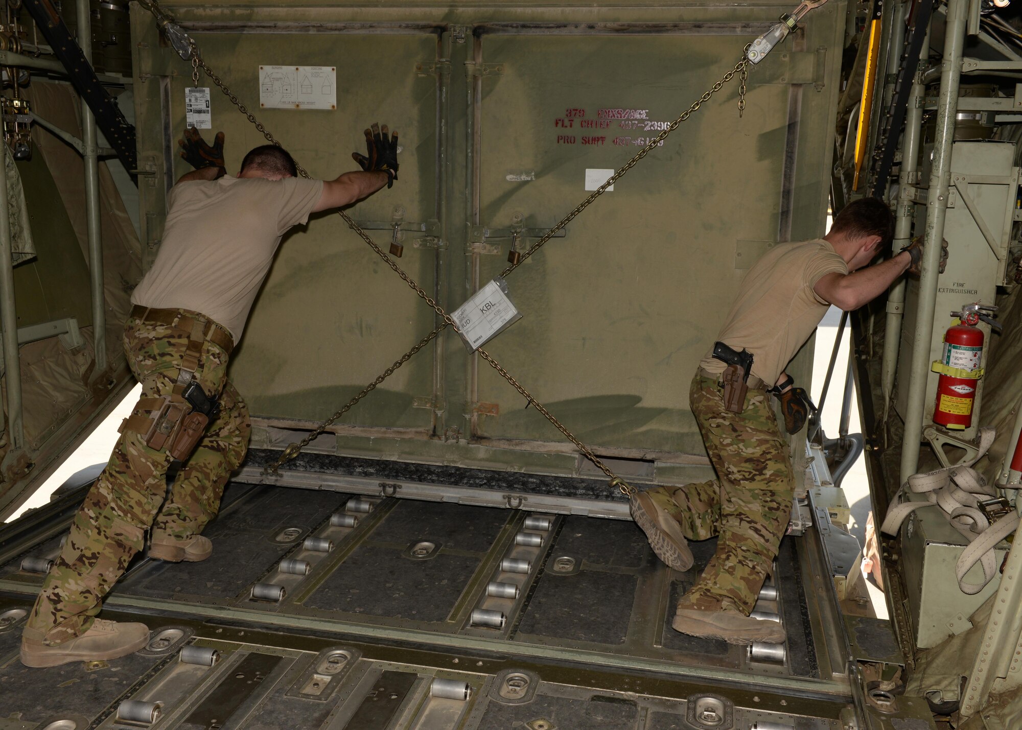 C-130J Super Hercules loadmasters push heavy cargo out of an aircraft Aug. 28, 2015, at Mazar-e-Sharif, Afghanistan. The loadmasters are deployed from Little Rock Air Force Base, Arkansas, and are responsible for delivering mission essential cargo and passenger to various forward operating bases within the area of responsibility. (U.S. Air Force photo by Senior Airman Cierra Presentado/Released)