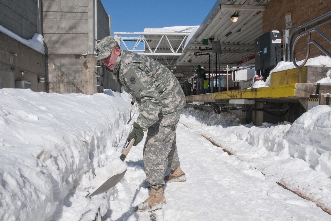 Massachusetts Army National Guard Staff Sgt. John Larrabee shovels snow away from the tracks at the Braintree Red Line station in Marblehead, Mass., Feb. 20, 2015. Guardsmen were assisting the Massachusetts Bay Transportation Authority with snow clearing operations following winter storms that caused major snow accumulation across the commonwealth. Larrabee is assigned to the 125th Quartermaster Company in Douglas, Mass. Massachusetts Army National Guard photo by Sgt. Michael Broughey