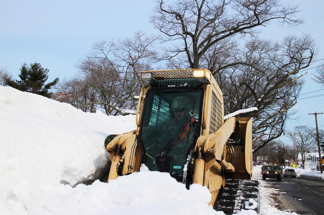 Massachusetts Army National Guardsmen with the 379th Engineer Company work alongside members of the Avon Department of Public Works  in Marblehead, Mass., Feb. 21, 2015, to clear roadways following a series of winter storms which dumped record amounts of snow across the Bay State. Massachusetts Army National Guard photo by Sgt. Alfred Tripolone III 