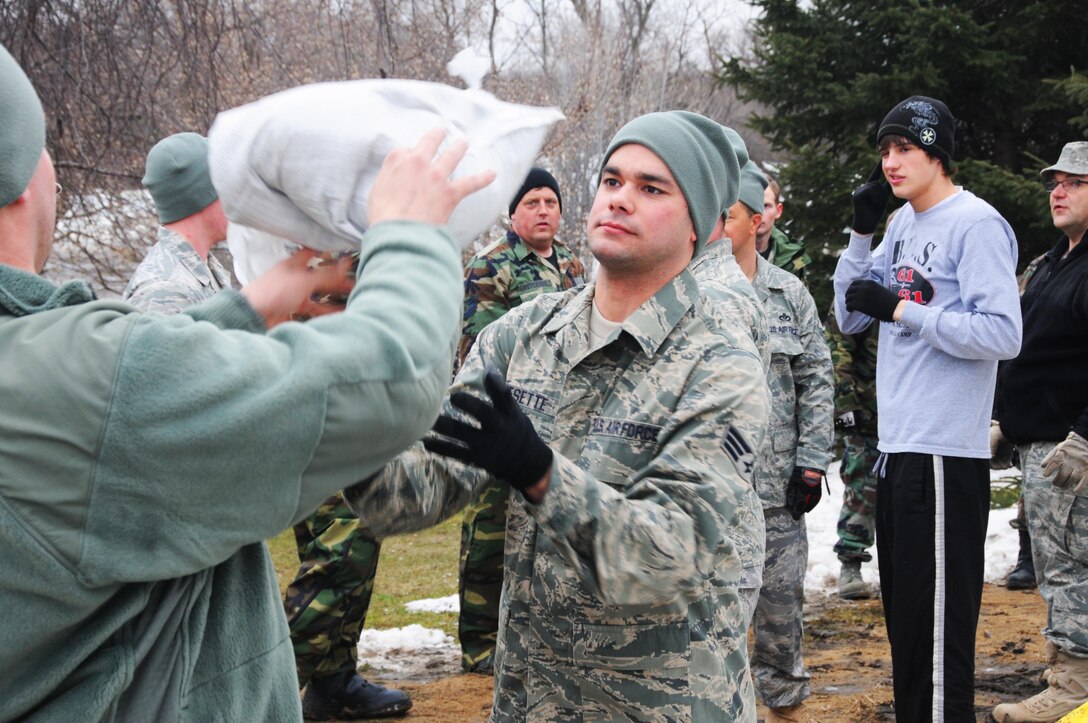 North Dakota Air National Guard Senior Airman Travis Besette, center, works as part of a human chain of Air National Guardsmen and civilian volunteers from the area high school during sandbagging efforts in Fargo, N.D., March 16, 2015. Besette is assigned to the 119th Civil Engineer Squadron. North Dakota Air National Guard photo by Senior Master Sgt. David H. Lipp