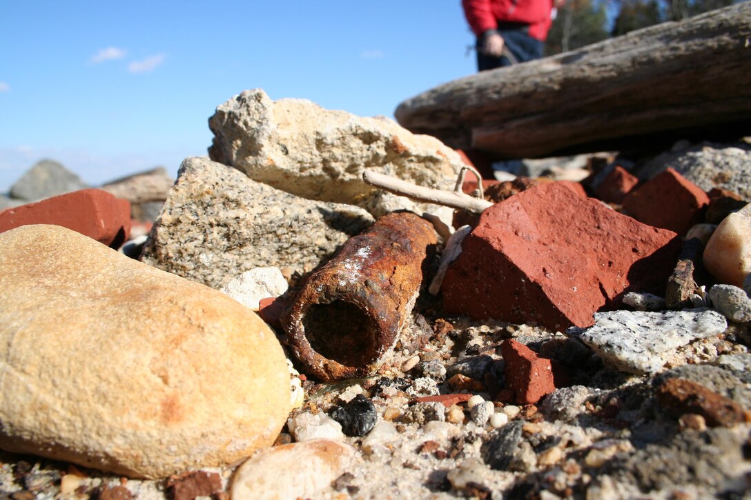 SUFFOLK, Va. -- A piece of ordnance lays among rocks on the beach at the Former Nansemond Ordnance Depot Dec. 2, 2005. In 1987 the Former Nansemond Ordnance Depot  became a matter of public concern when a piece of crystalline TNT was found at the Tidewater Community College, Portsmouth Campus. Extensive historical research, investigations, and testing led the U.S. Environmental Protection Agency to place this site on the National Priority list in 1999. The U.S. Army Corps of Engineers has managed the clean-up project on this site since. (U.S. Army photo/Patrick Bloodgood)