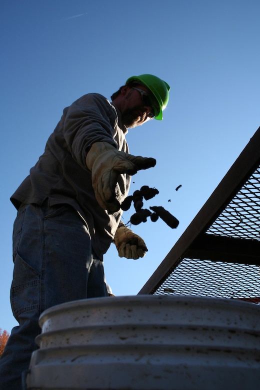 SUFFOLK, Va. -- A contractor sorts through debris as he searches for munitions at the Former Nansemond Ordance Depot Dec. 2, 2005. In 1987 the Former Nansemond Ordnance Depot  became a matter of public concern when a piece of crystalline TNT was found at the Tidewater Community College, Portsmouth Campus. Extensive historical research, investigations, and testing led the U.S. Environmental Protection Agency to place this site on the National Priority list in 1999. The U.S. Army Corps of Engineers has managed the clean-up project on this site since. (U.S. Army photo/Patrick Bloodgood) 