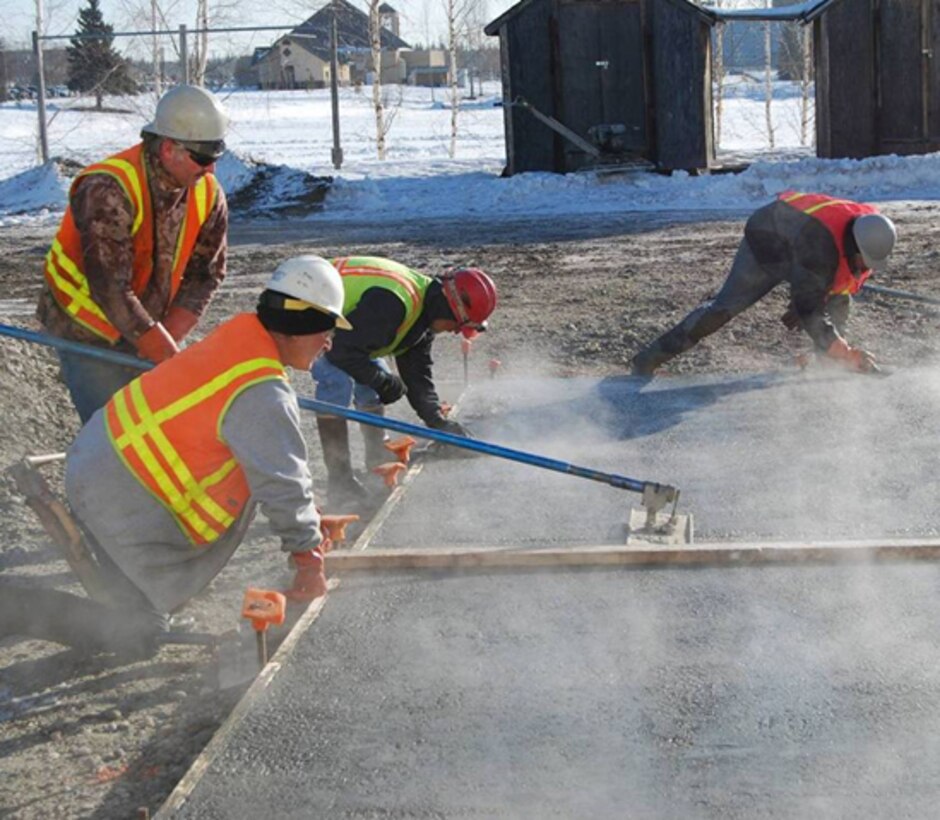 Contractors finish the surface of a concrete slab constructed with antifreeze concrete during a field demonstration at Fort Wainwright, Alaska, in March 2015. The air temperature was 14oF (−10oC).