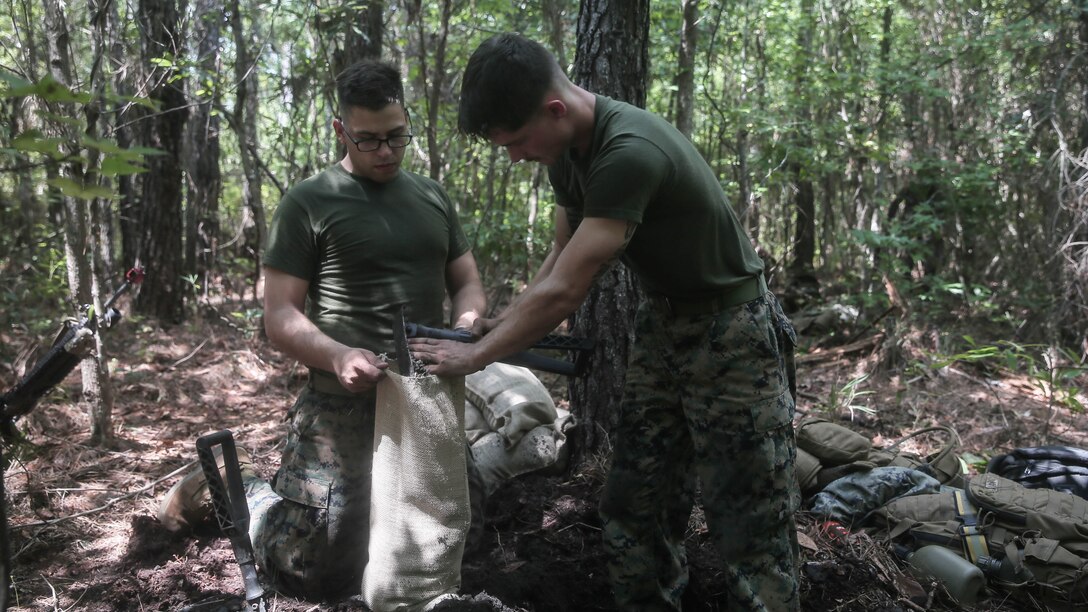 Marines with Charlie Company, 1st Battalion, 8th Marine Regiment, dig skirmishers trenches and fill sandbags during a field exercise aboard Camp Lejeune, N.C., Aug. 25, 2015. Marines hiked to Training Landing Zone Swan, set up defensive and offensive positions then waited to encounter simulated attacks, in preparation for their upcoming deployment with Special Purpose Marine Air Ground Task Force Crisis Response. 