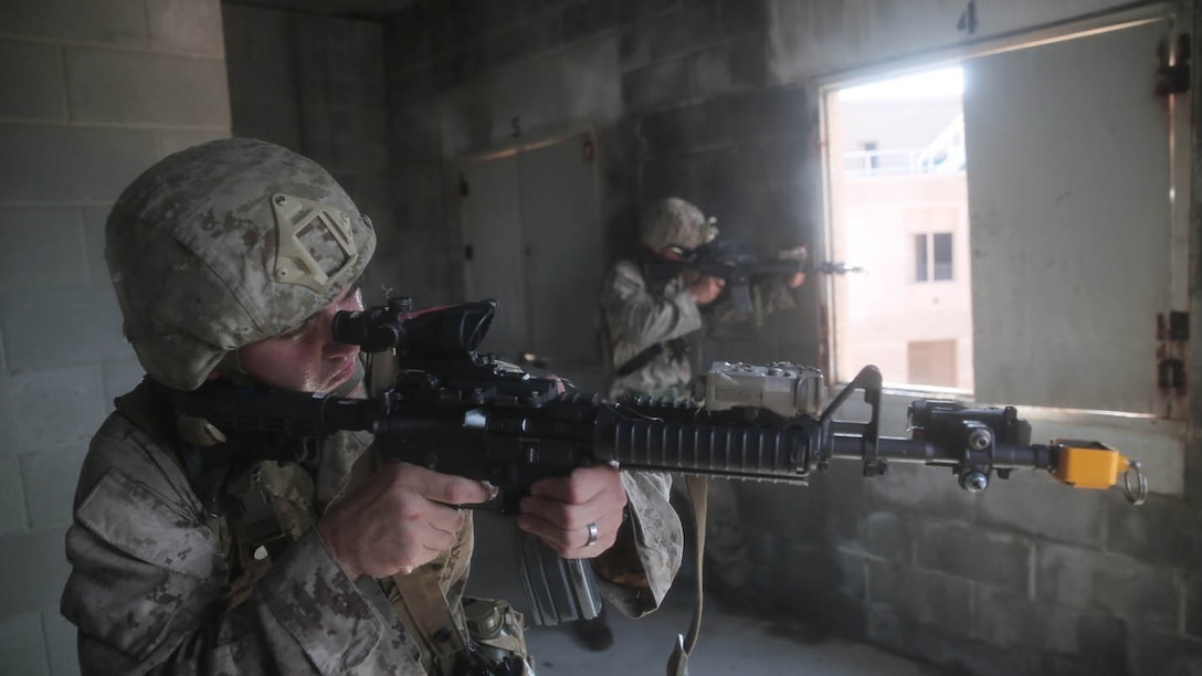 Marines with multiple units assist Marines with Charlie Company, 1st Battalion, 8th Regiment, by acting as the opposing forces occupying this simulated village during a field exercise aboard Camp Lejeune, N.C., Aug. 25, 2015. Marines with 1/8 assaulted a simulated town, set up a defensive position and waited to repel simulated attacks in preparation for their upcoming deployment with Special Purpose Marine Air Ground Task Force Crisis Response. 