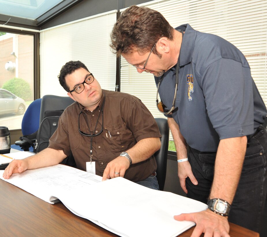 Huntsville Center mechanical engineer Scott L. Sheffield and Energy Engineering Analysis Program Manager Raúl E. Alonso discuss HVAC system features detailed in the building plans for the commissary at Redstone Arsenal, Alabama. Huntsville Center's EEAP team is preparing a comprehensive energy reduction plan for the Defense Commissary Agency's West Area sites and toured the Redstone facility to get a better understanding of commissary operations and typical energy consumption.