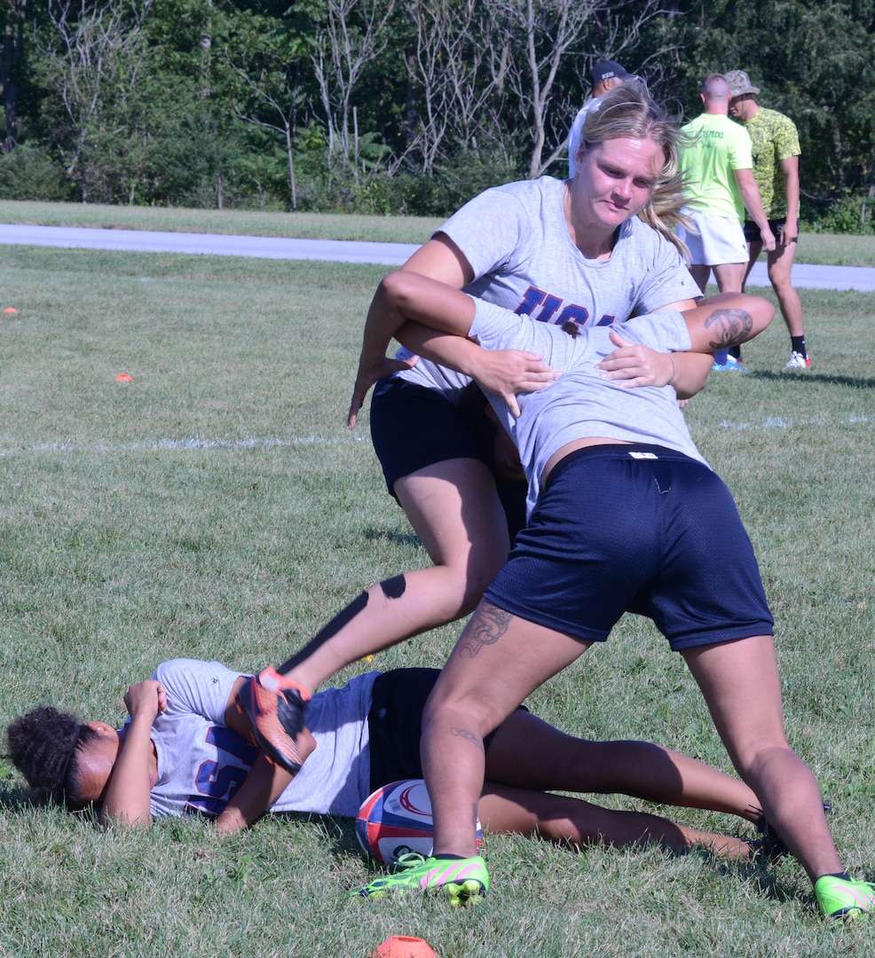 Capt. Ashley Sorensen practices kicking the ball back to her team after a player has been tackled during the first-ever Armed Forces women's rugby training camp at Fort Indiantown Gap, Pa., Aug. 25, 2015. Sorensen holds the world's record for running one mile in a full bomb suit.