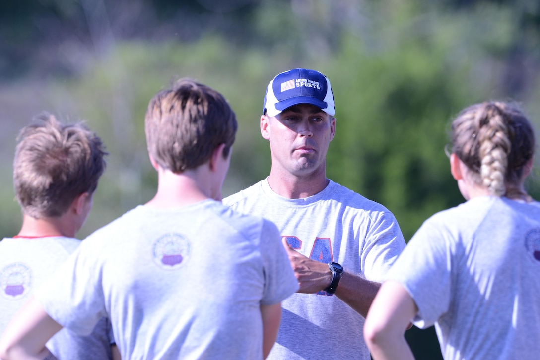 Capt. Andrew Locke, coach of the Armed Forces Women's Rugby Team, provides instruction on running drills on the pitch at Fort Indiantown Gap, Pa., Aug. 25, 2015.