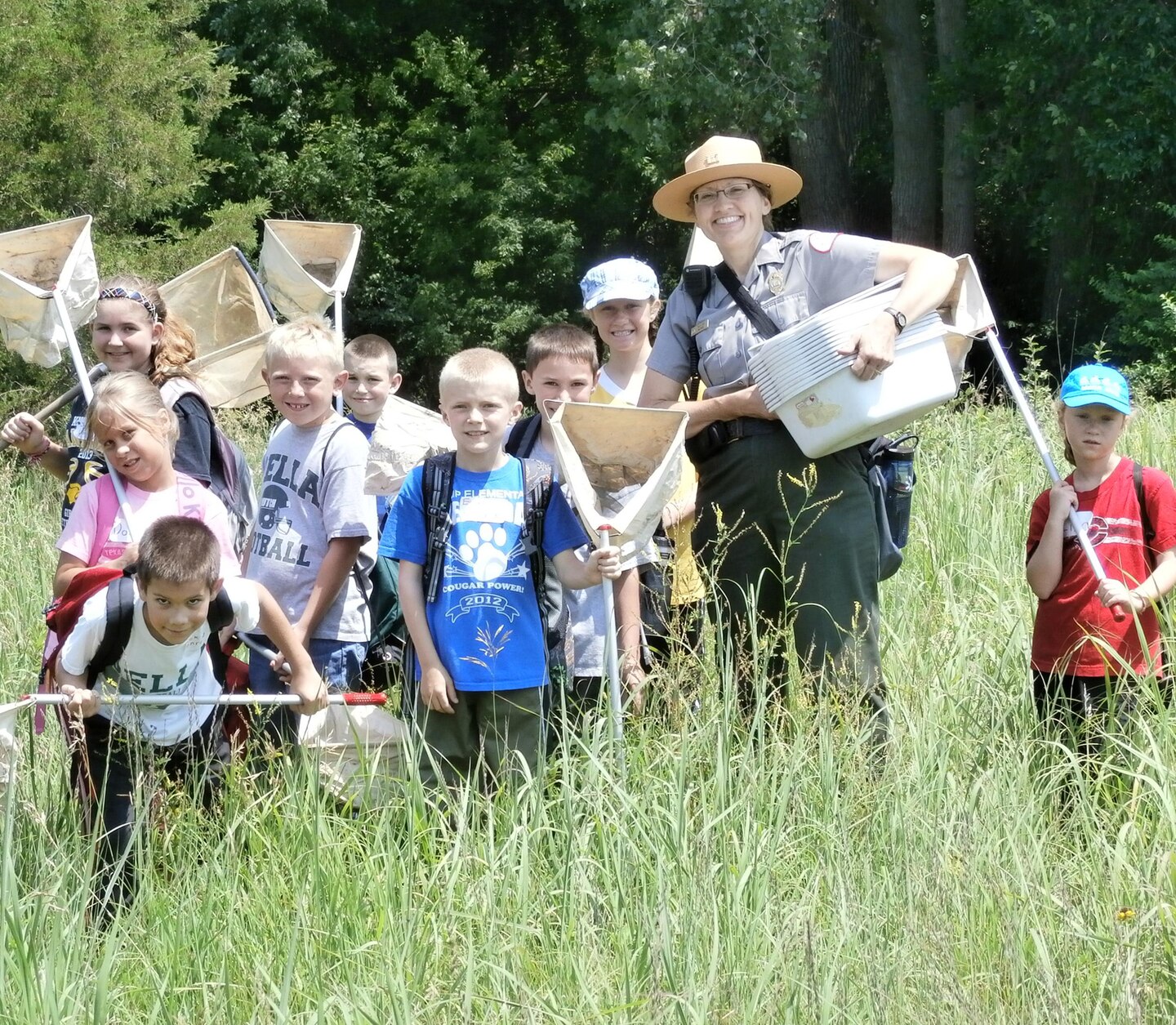 Rock Island District Park Ranger, Tracy Spry, stands with some students attending a Jr. Ranger program at Lake Red Rock in 2014.     